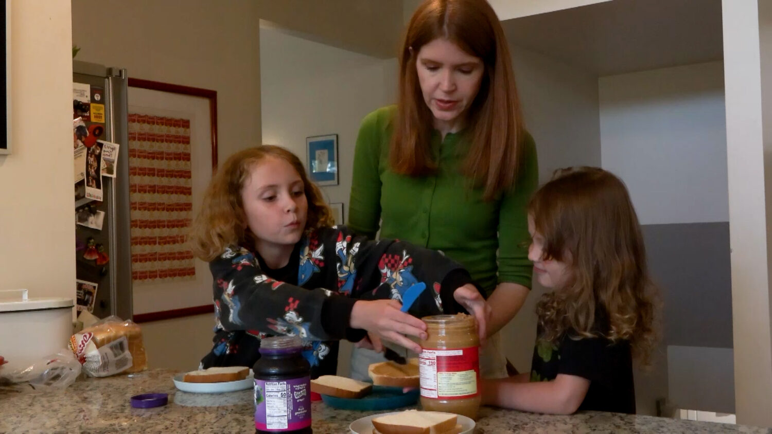 Tracy Keck and her two kids preparing sandwiches for lunch, Thursday. Keck prioritizes getting flu shots for herself and her family.