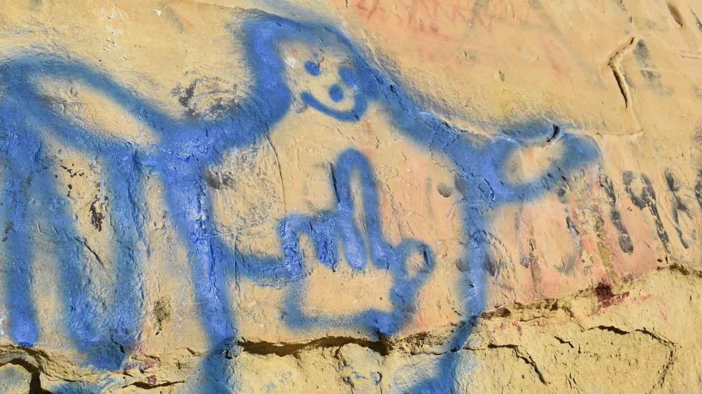 Graffiti over a rock imagery panel.