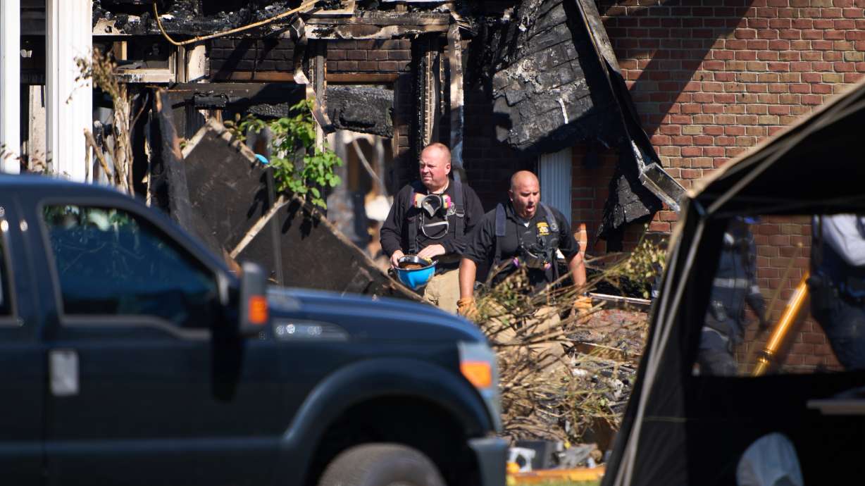 Investigators walk in The Church of Jesus Christ of Latter-day Saints in Grand Blanc Township, Mich., where Sunday a man rammed his vehicle into the building before opening fire and setting the building ablaze, Tuesday. Police released bodycam footage Friday.