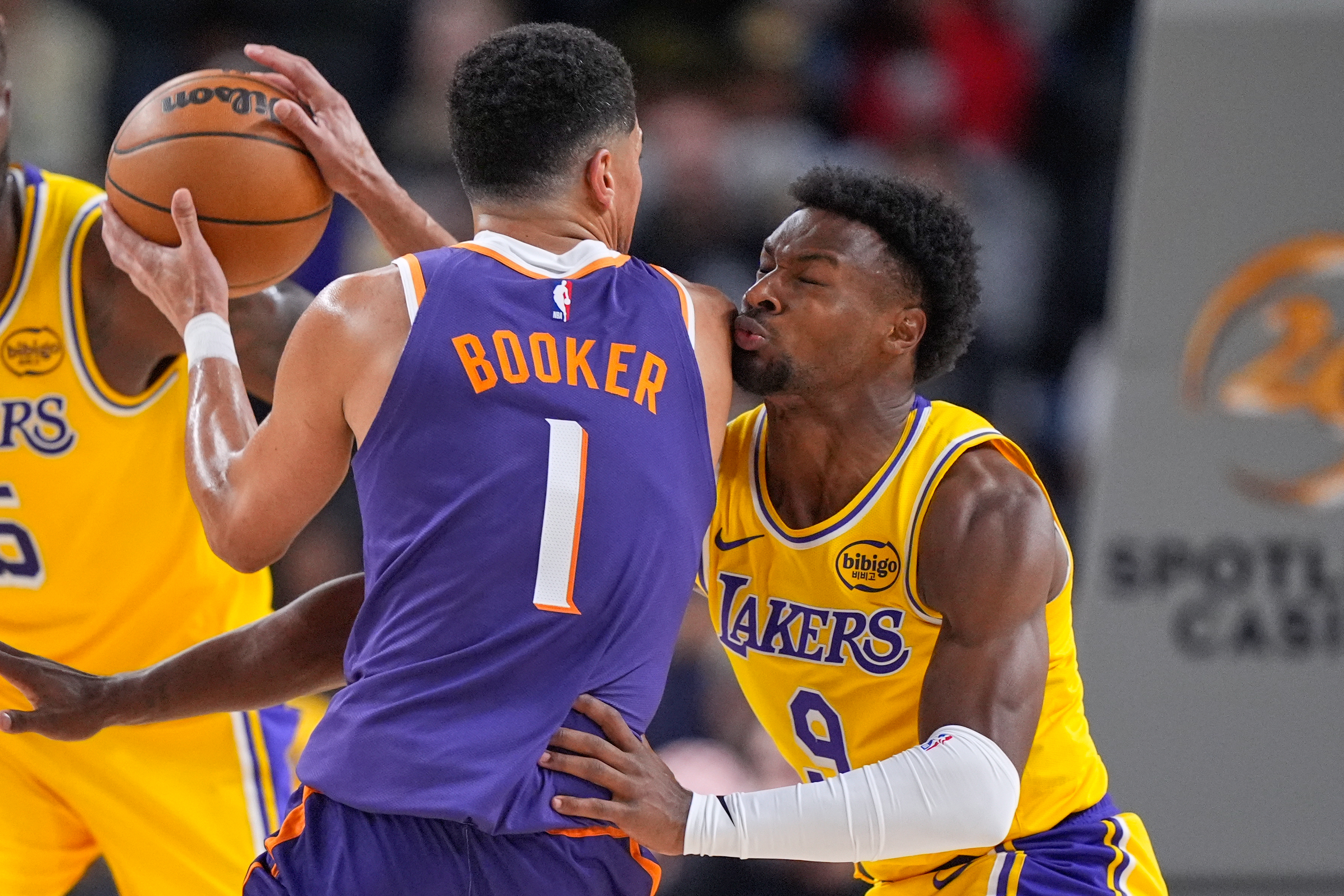 Phoenix Suns guard Devin Booker, left, tries to get by Los Angeles Lakers guard Bronny James during the first half of an NBA preseason basketball game Friday, Oct. 3, 2025, in Palm Desert, Calif.