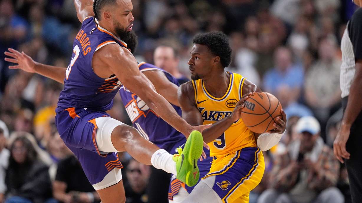 Los Angeles Lakers guard Bronny James, right, tries to pass while under pressure from Phoenix Suns forward Dillon Brooks during the second half of an NBA preseason basketball game Friday, Oct. 3, 2025, in Palm Desert, Calif.