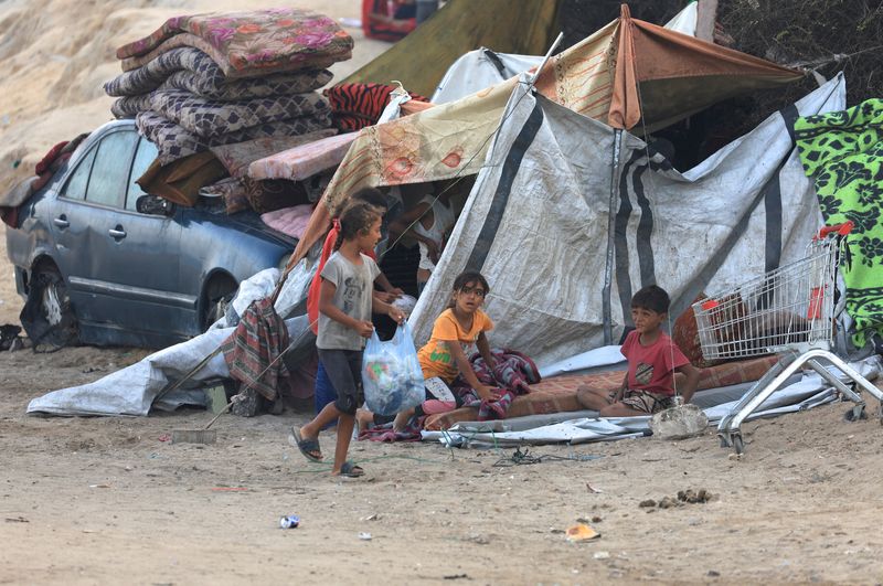Displaced Palestinians sit next to a tent, after Hamas agreed to release hostages and accept some other terms in a U.S. plan to end the war, in the central Gaza Strip, Saturday.