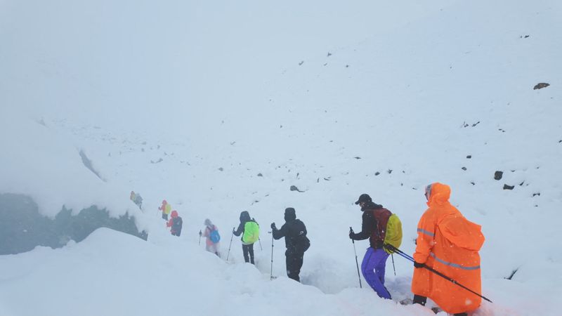 A screen capture from video shows trekkers leaving their campsite, as unusually heavy snow and rainfall pummeled the Himalayas, in the Tibet Region, China, Sunday.