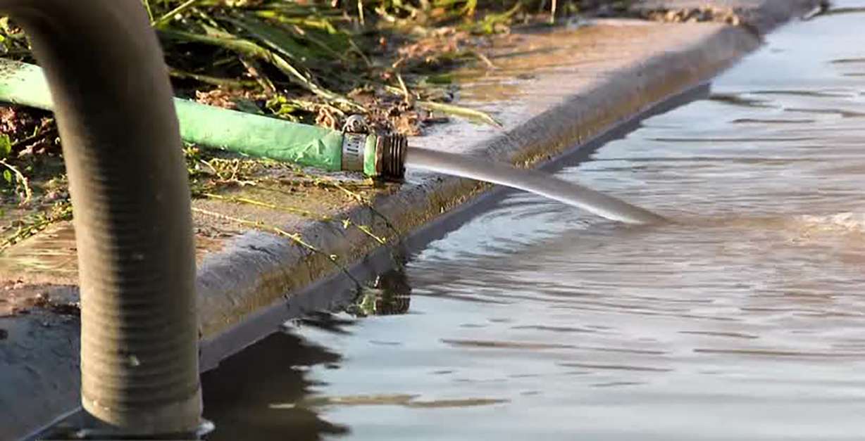 People helped drain water from damaged homes in Rose Park on Sunday after historic rain caused major flooding to many homes.