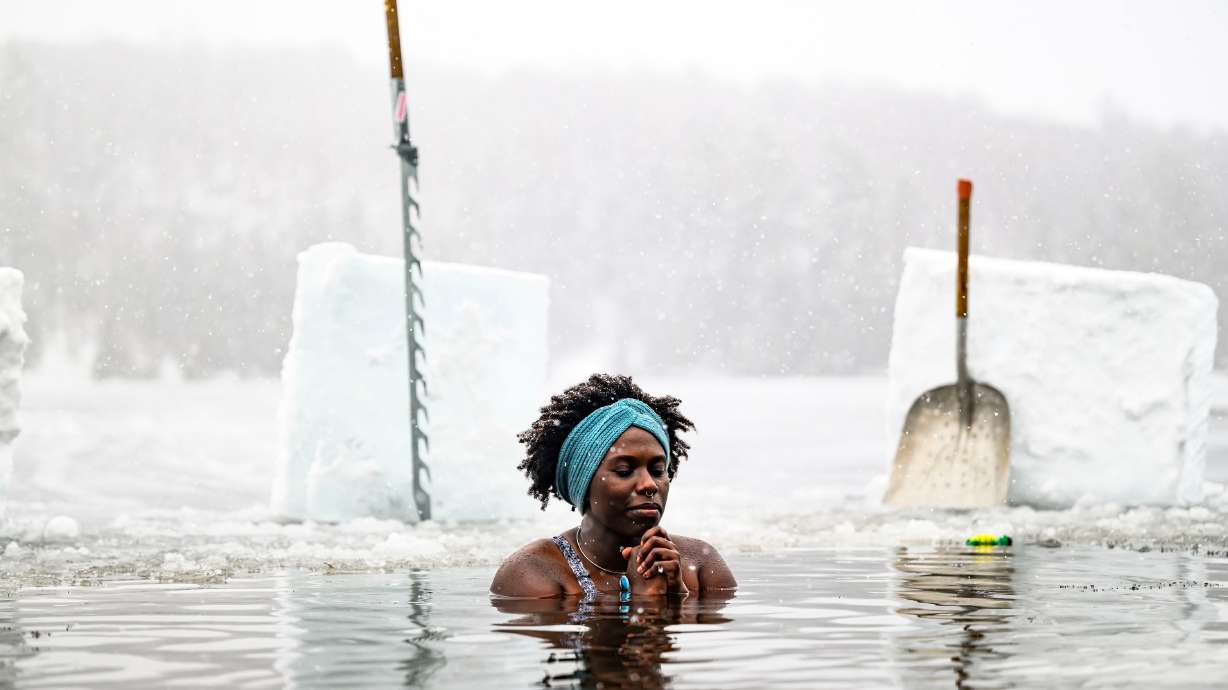 FILE - Canda-Leigh Habonimana dips in the waters of Gatineau Park's Meech Lake in Chelsea, Que., during a polar bear dip on New Year's Day, Jan. 1, 2025.