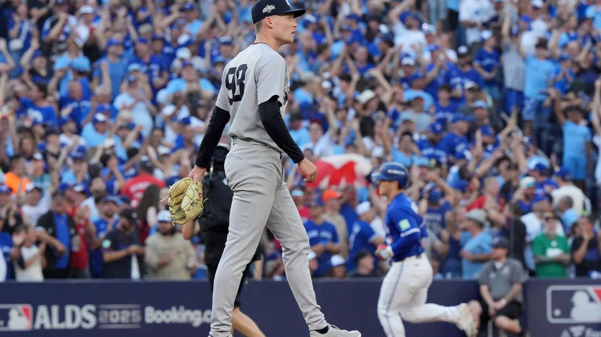New York Yankees pitcher Will Warren, foreground, reacts as Toronto Blue Jays' Daulton Varsho, back right, rounds the bases after hitting a two-run home run during the fourth inning of Game 2 of baseball's American League Division Series in Toronto, Sunday, Oct. 5, 2025.
