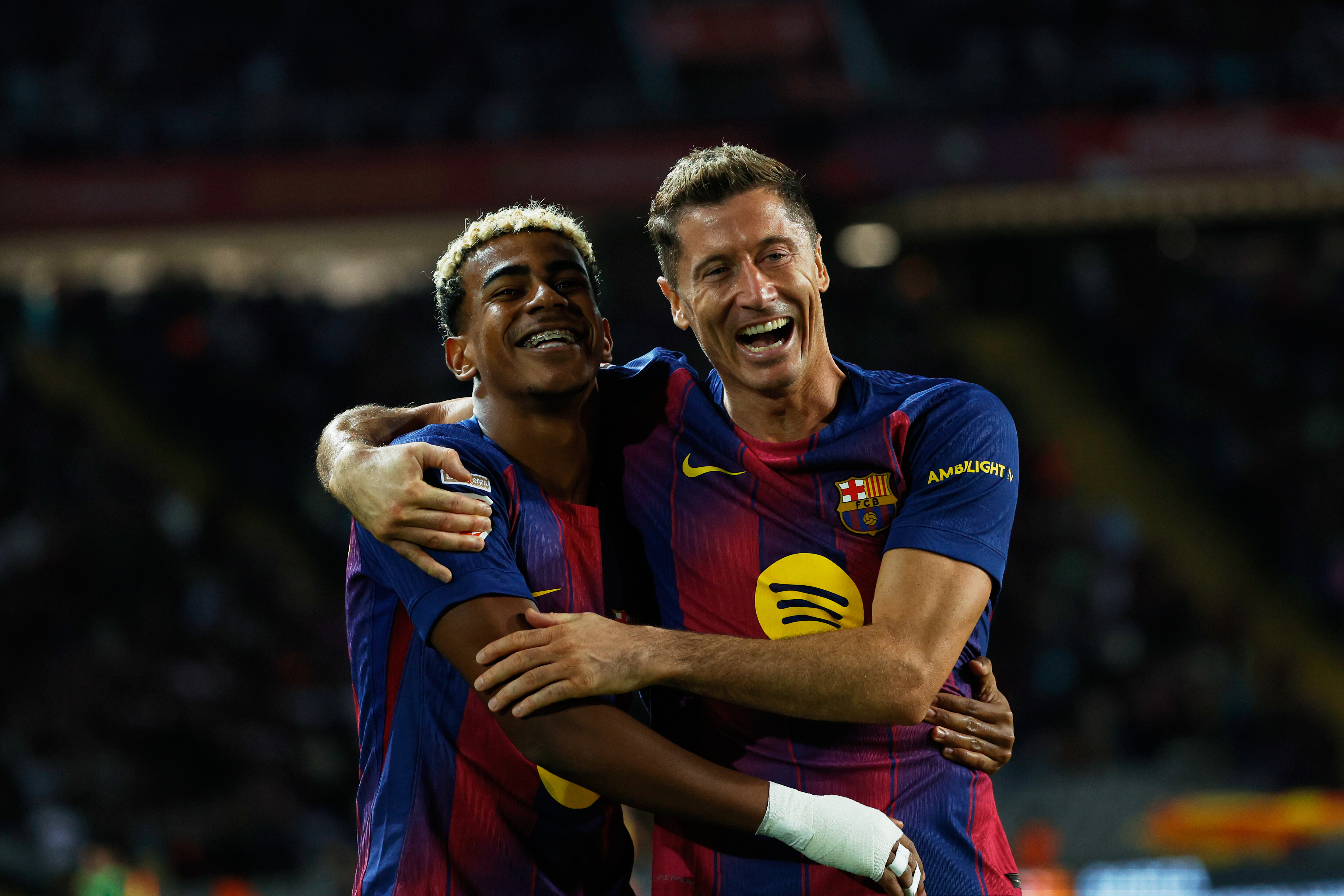 Barcelona's Robert Lewandowski, right, celebrates with Lamine Yamal scoring his side's 2nd goal during a Spanish La Liga soccer match between FC Barcelona and Real Sociedad at the Lluis Companys Olympic Stadium in Barcelona, Spain, Sunday, Sept. 28, 2025.