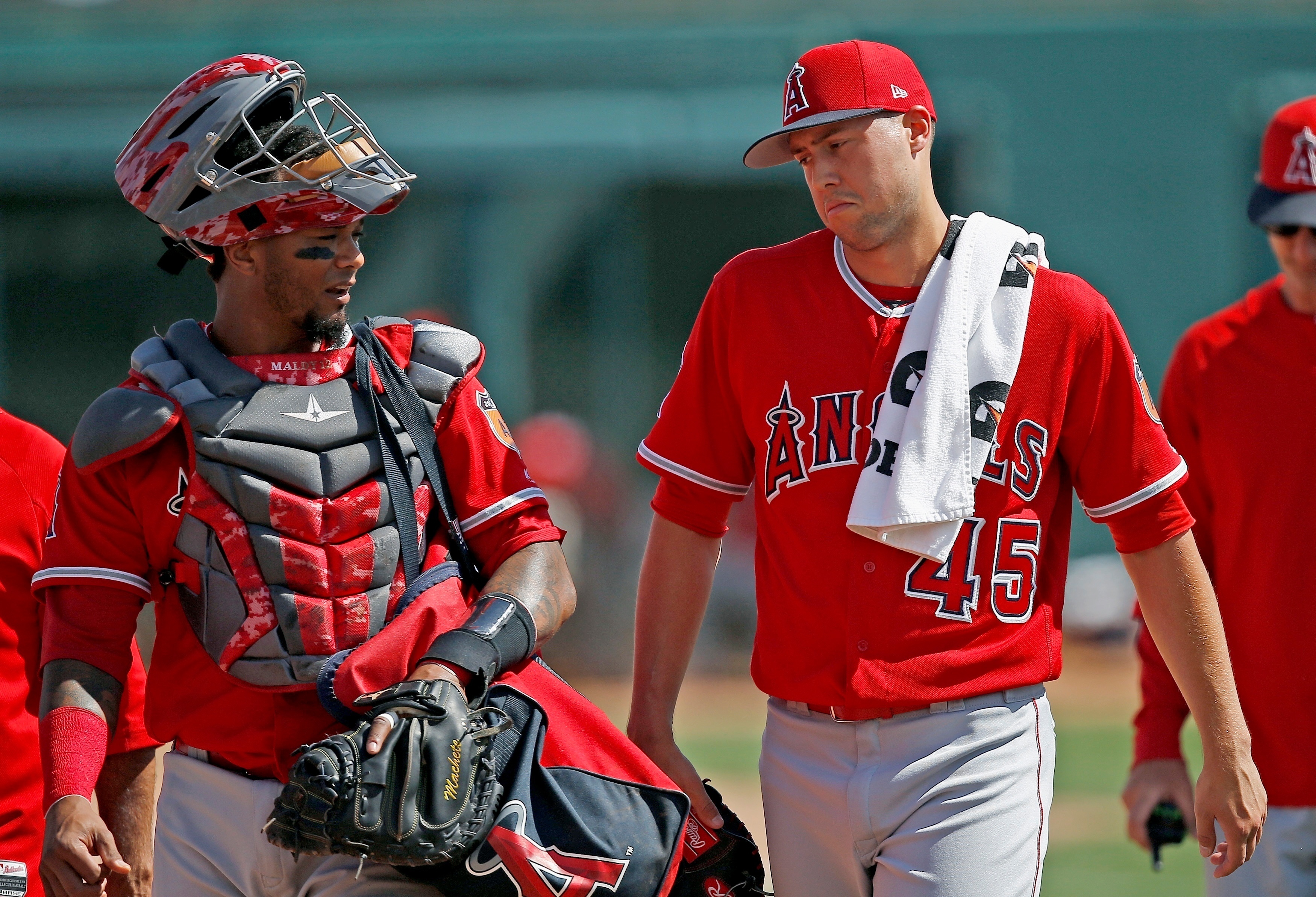FILE - Los Angeles Angels starting pitcher Tyler Skaggs (45) talks with catcher Martin Maldonado, left, after warming up in the bullpen prior to a spring training baseball game against the Chicago White Sox, March 4, 2017, in Glendale, Ariz.