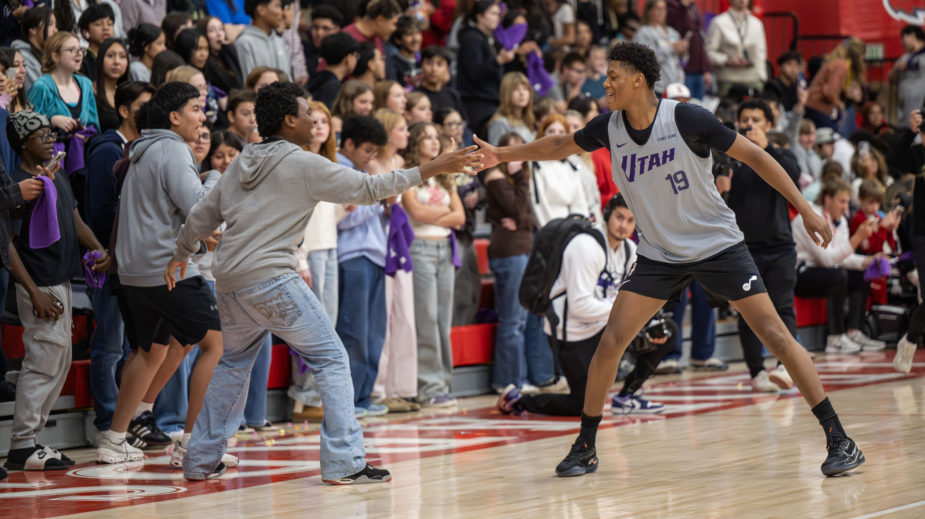 Ace Bailey high-fives a student as the Utah Jazz surprise the students of East High School with a scrimmage in their gym in Salt Lake City, on Monday, Oct. 6, 2025.