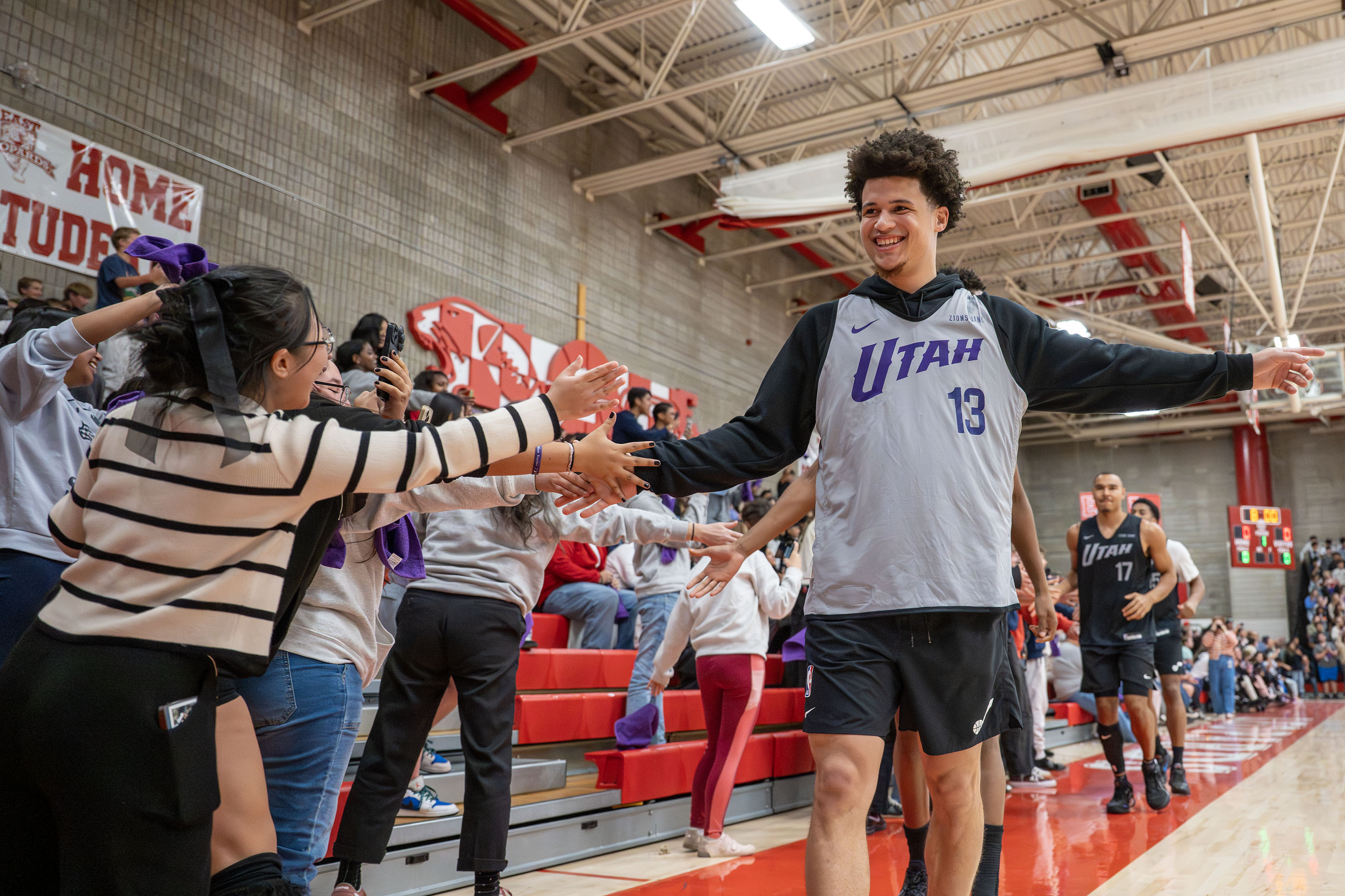 Walter Clayton Jr. and the other members of the Utah Jazz greet the studets as they supprise them at East High School with a scrimmage in their gym in Salt Lake City, on Monday, Oct. 6, 2025.