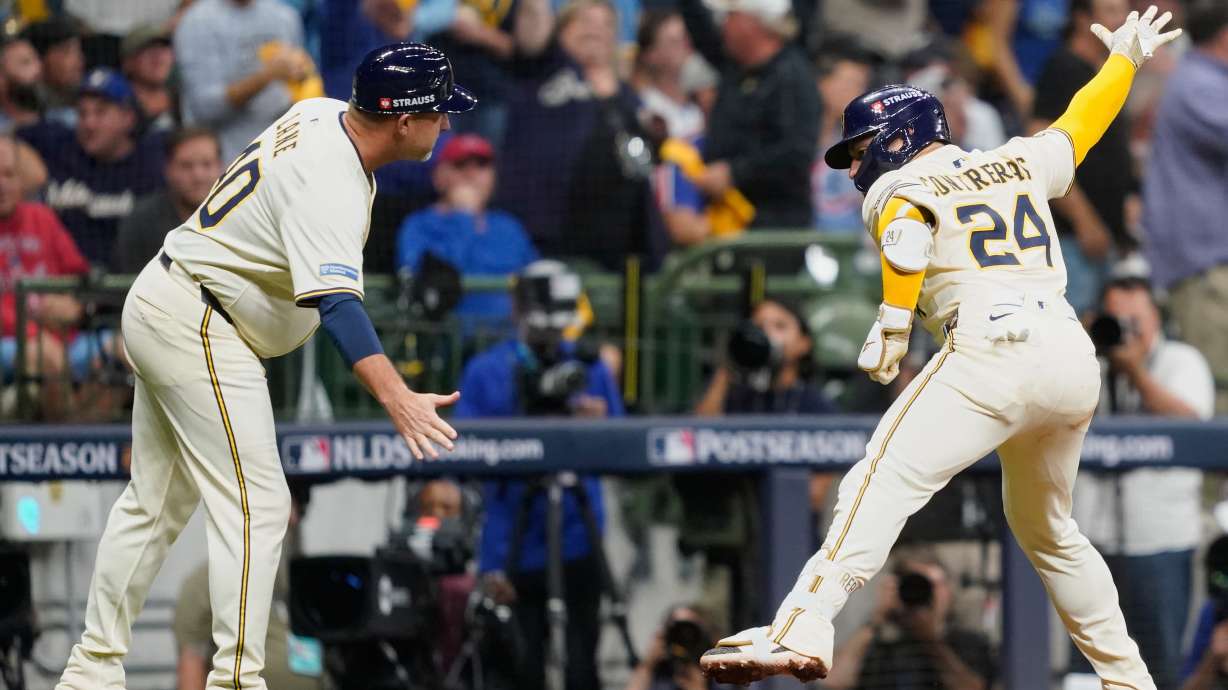 Milwaukee Brewers' William Contreras (24) celebrates with third base coach Jason Lane (40) after hitting a solo home run during the third inning of Game 2 of baseball's National League Division Series against the Chicago Cubs Monday, Oct. 6, 2025, in Milwaukee.