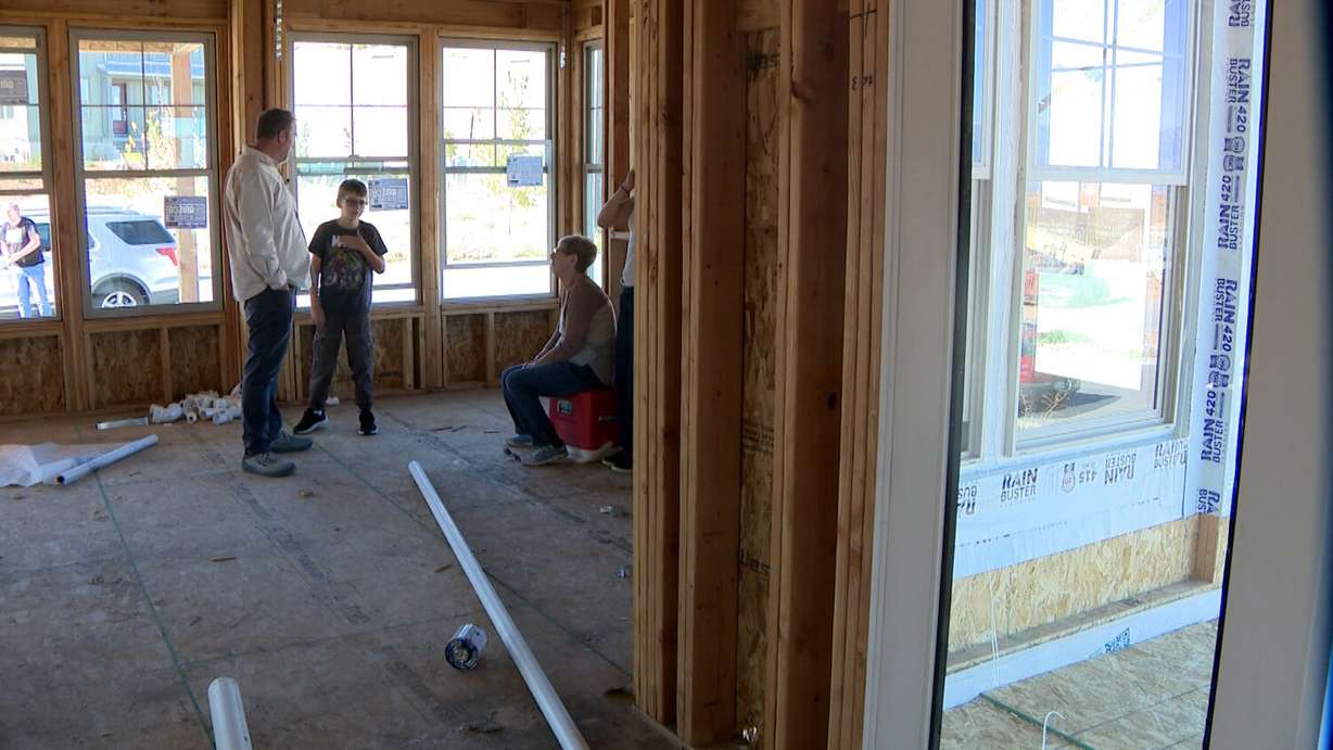 Scott Thomas, left, talks with his children and mother-in-law, Linda Rasmussen, inside their house under construction in Terraine, a new community in West Jordan, Monday.