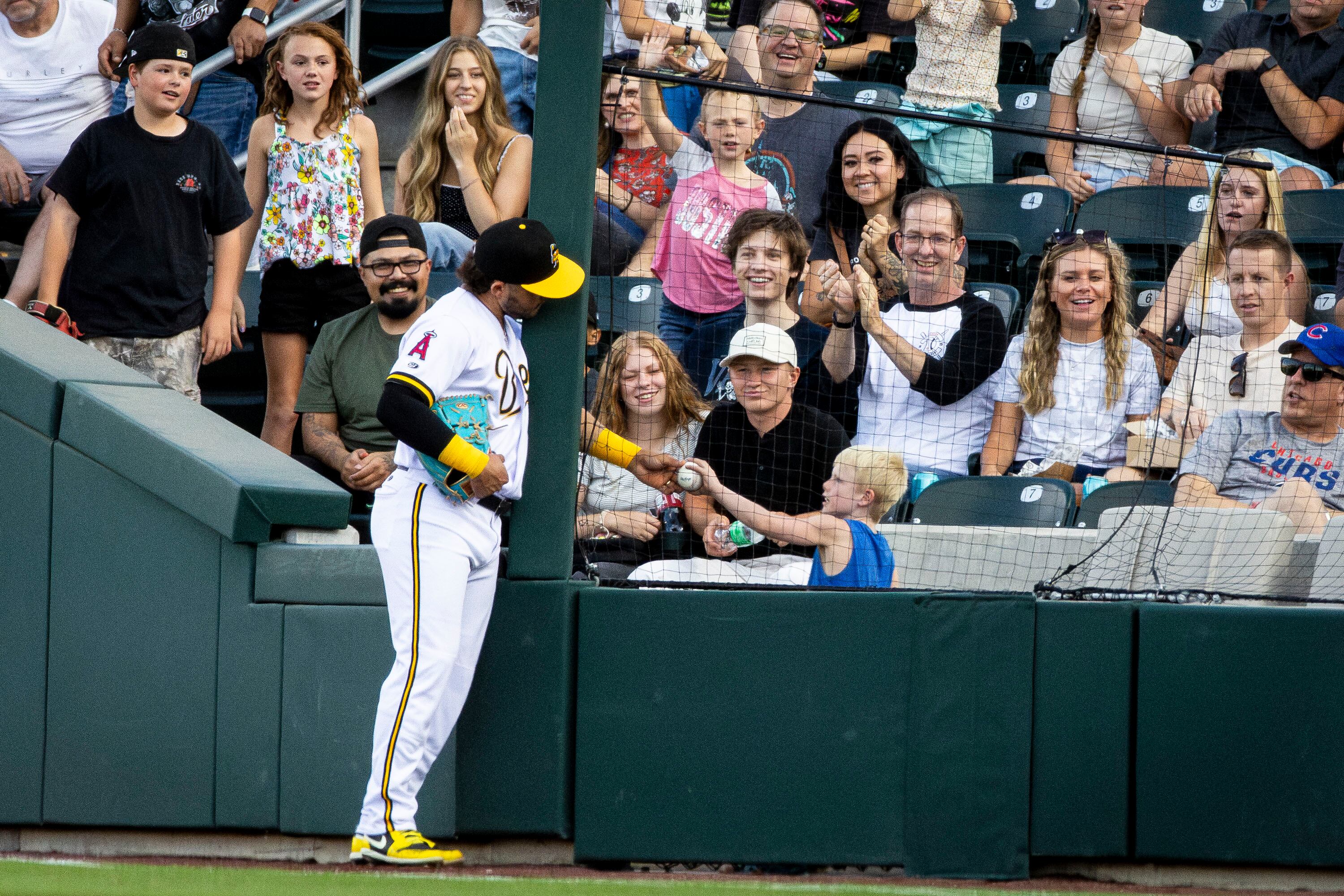 Salt Lake Bees infielder Yolmer Sánchez (8) hands a ball he caught for an out to Max Nokes, 7, of Taylorsville, during a Minor League Baseball game against the Albuquerque Isotopes held at The Ballpark at America First Square in South Jordan on July 22.