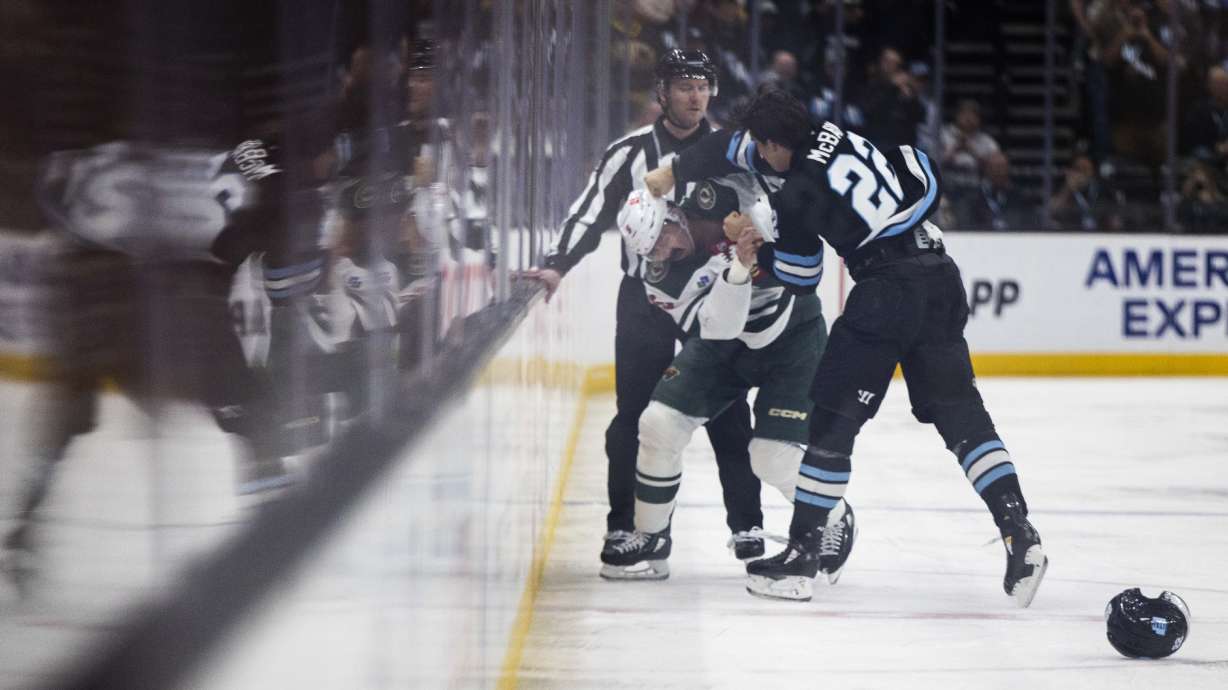 Utah Hockey Club center Jack McBain (22) and Minnesota Wild defenseman Jake Middleton (5) fight each other during an NHL game at the Delta Center in Salt Lake City on Thursday, Feb. 27, 2025. The Utah Hockey Club claimed victory over the Minnesota Wild, with a final score of 6-1.