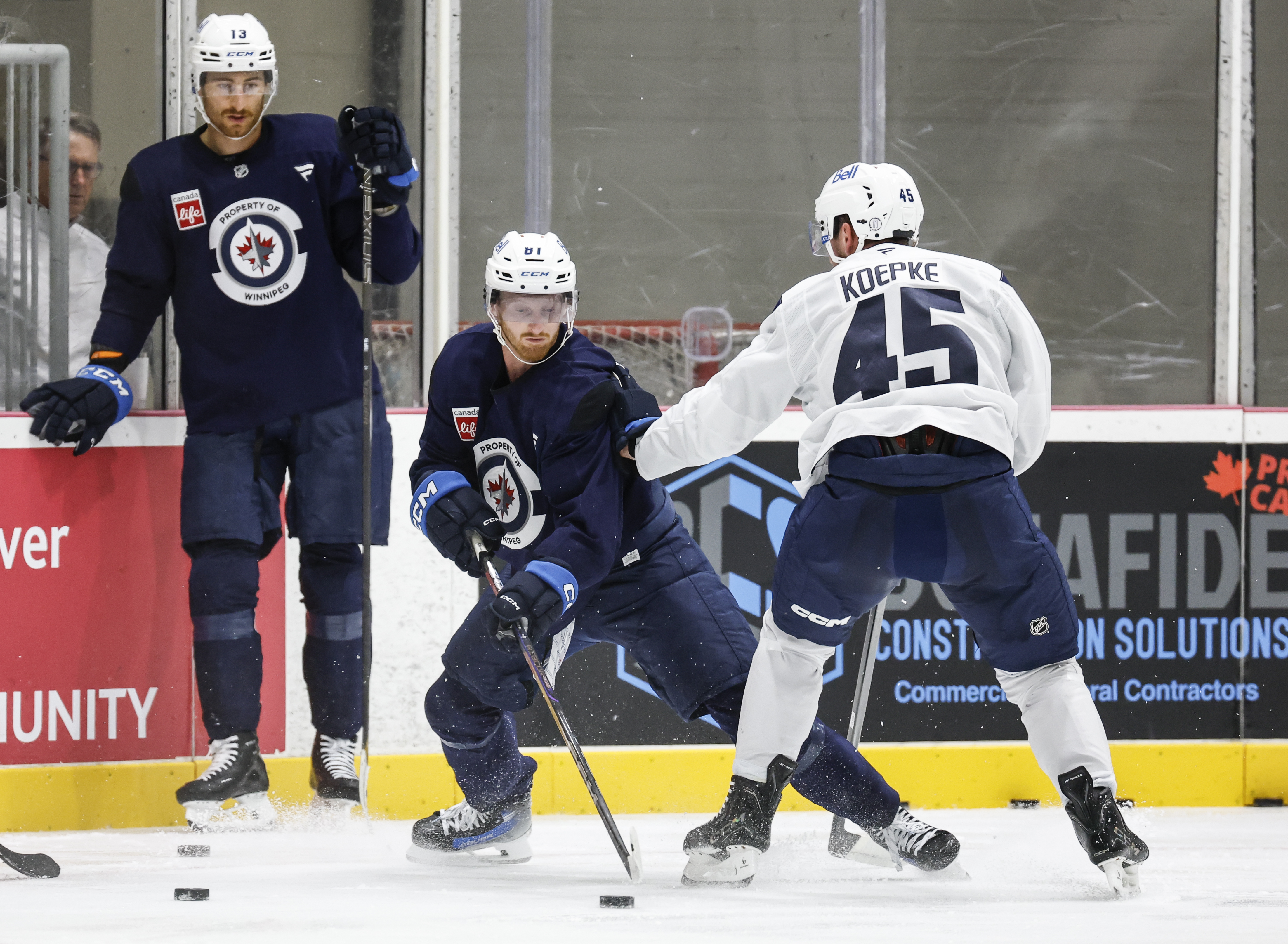 Winnipeg Jets' Gabriel Vilardi (13) looks on as Kyle Connor (81) and Cole Koepke (45) battle in the corner during NHL hockey training camp in Winnipeg, Manitoba, Thursday, Sept. 18, 2025. 