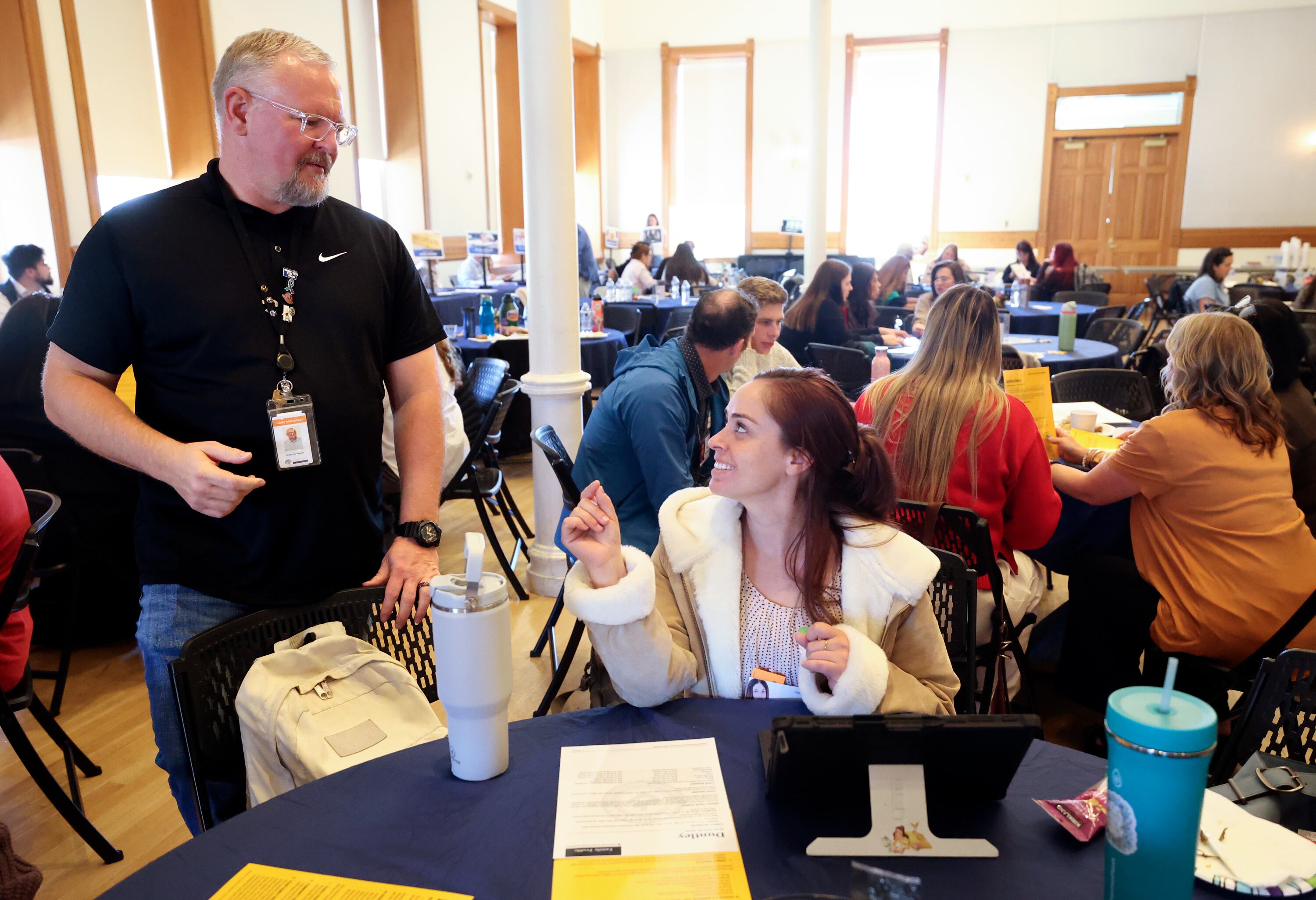 Cody Martensen, Circles coordinator, answers questions for EJ Caseres, Alpine School District outreach coordinator, about a poverty simulation at the kNOw Poverty Summit at Provo City Library at Academy Square in Provo on Wednesday.
