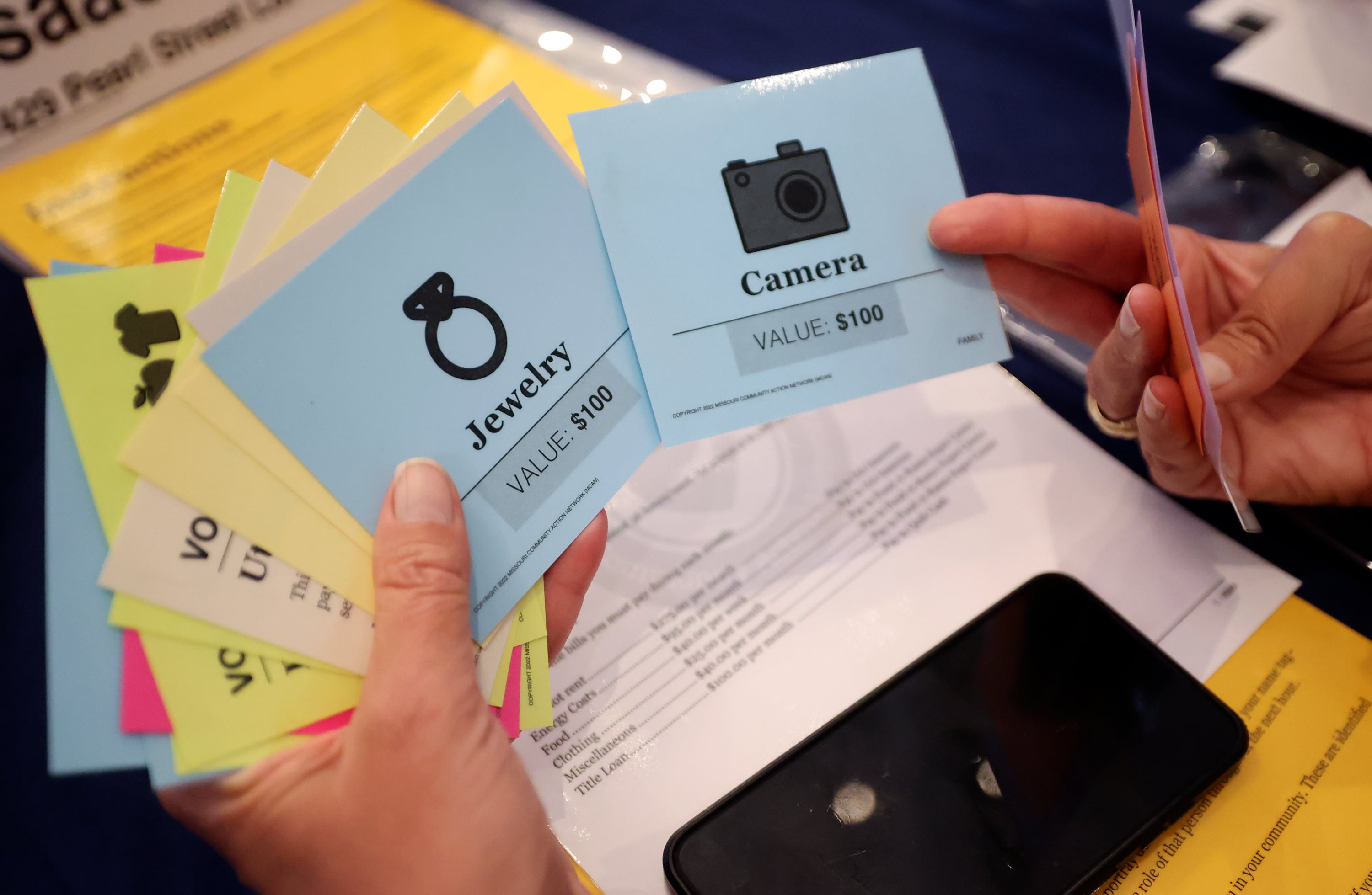 A participant weighs which possessions to sell during a poverty simulation at the kNOw Poverty Summit at Provo City Library at Academy Square in Provo on Wednesday.