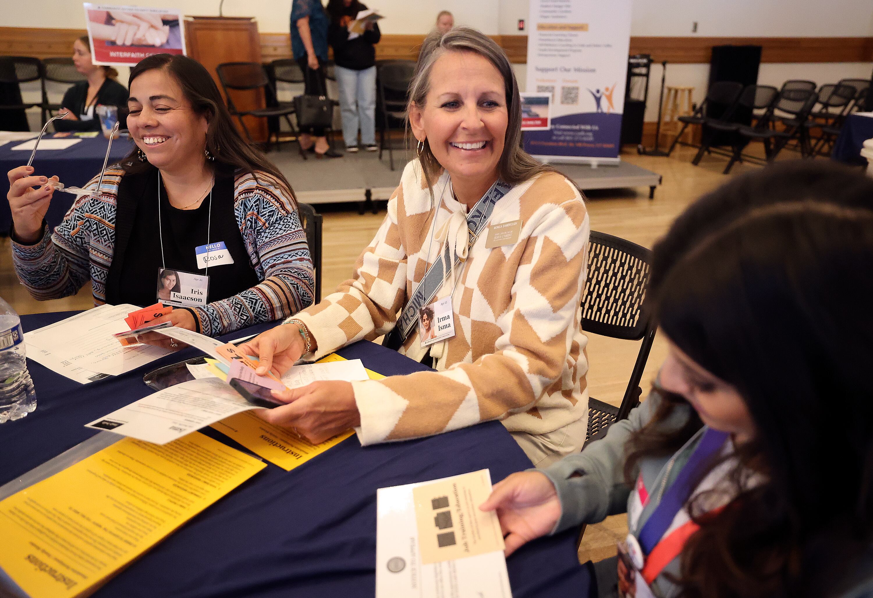 Rosa Quintero, The Refuge Utah case manager, and Monica Bambrough, The Church of Jesus Christ of Latter-day Saints Mount Nebo Communication Council assistant director, and Vanessa Rivera, Utah County resource integration coach, participate in a poverty simulation at the kNOw Poverty Summit at Provo City Library at Academy Square in Provo on Wednesday.