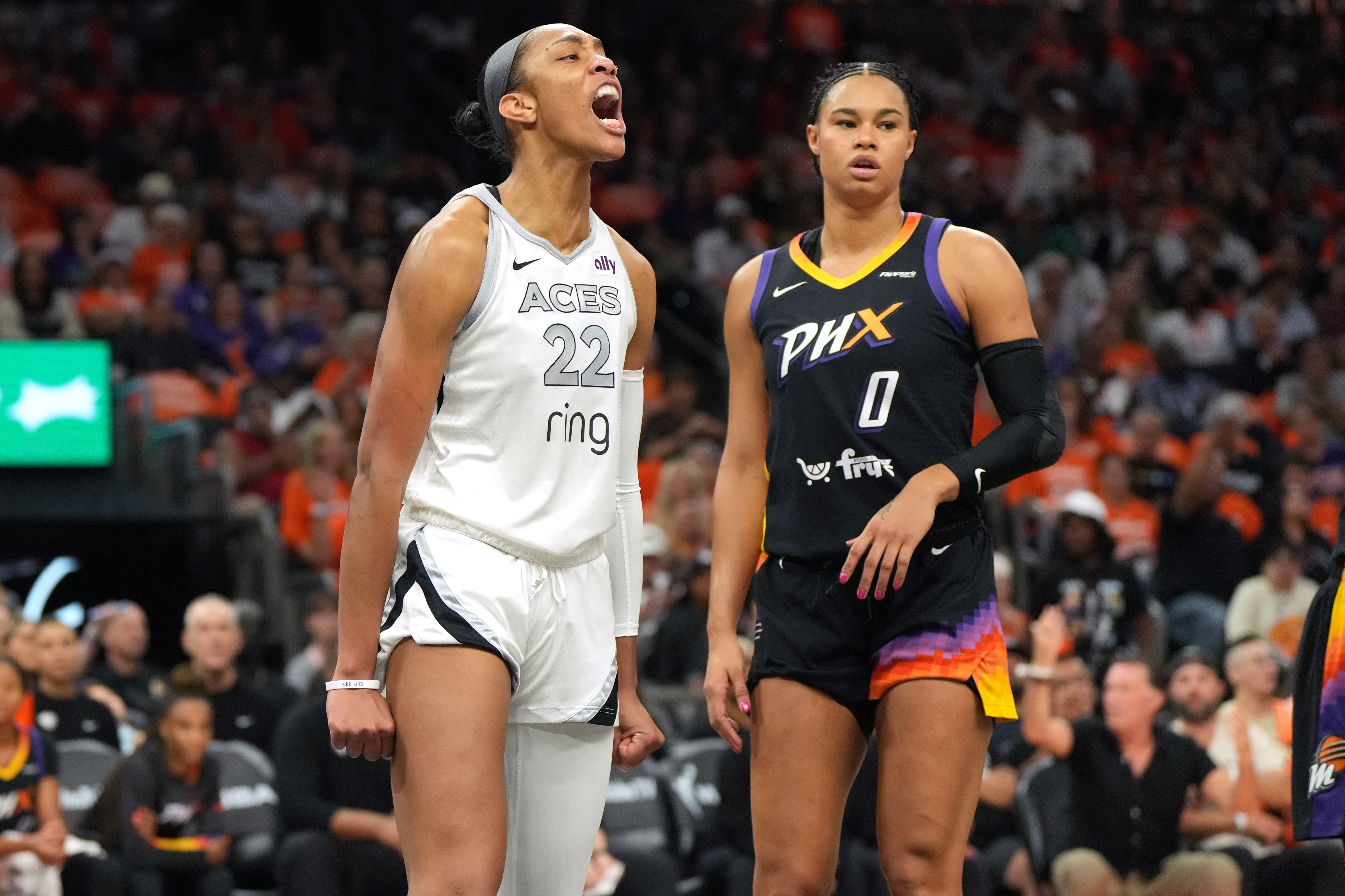Las Vegas Aces center A'ja Wilson (22) reacts after scoring on Phoenix Mercury forward Satou Sabally during the first half of Game 3 of the WNBA basketball finals, Wednesday, Oct. 8, 2025, in Phoenix. 