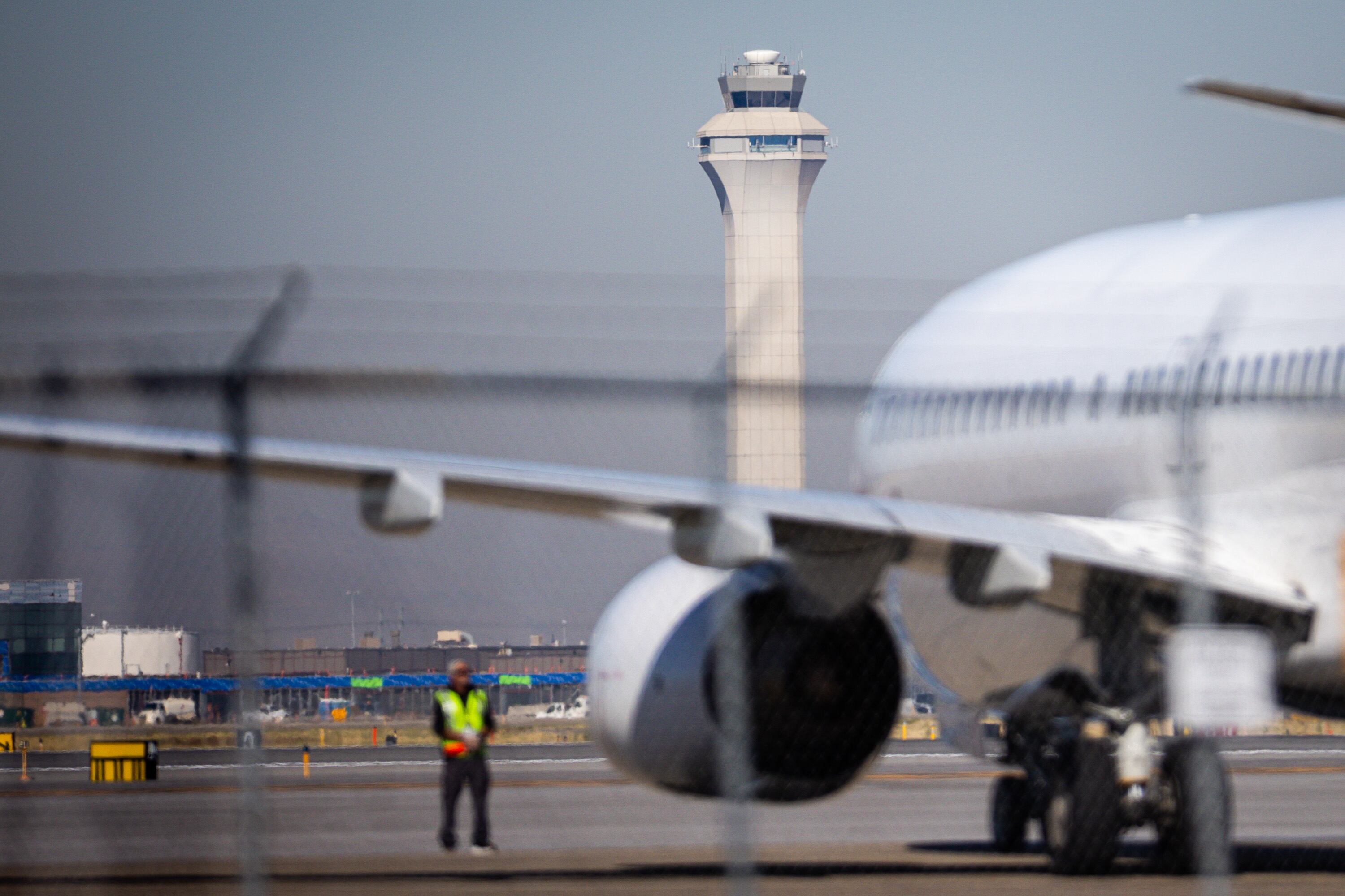 A plane prepares to take off near the airport traffic control tower at Salt Lake City International Airport in Salt Lake City on Wednesday.