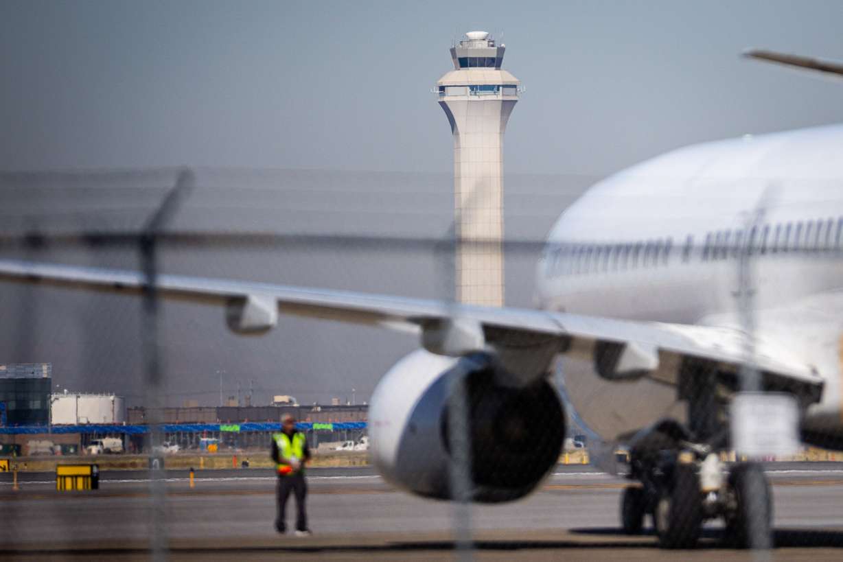 A plane prepares to take off near the airport traffic control tower at Salt Lake City International Airport in Salt Lake City on Wednesday.