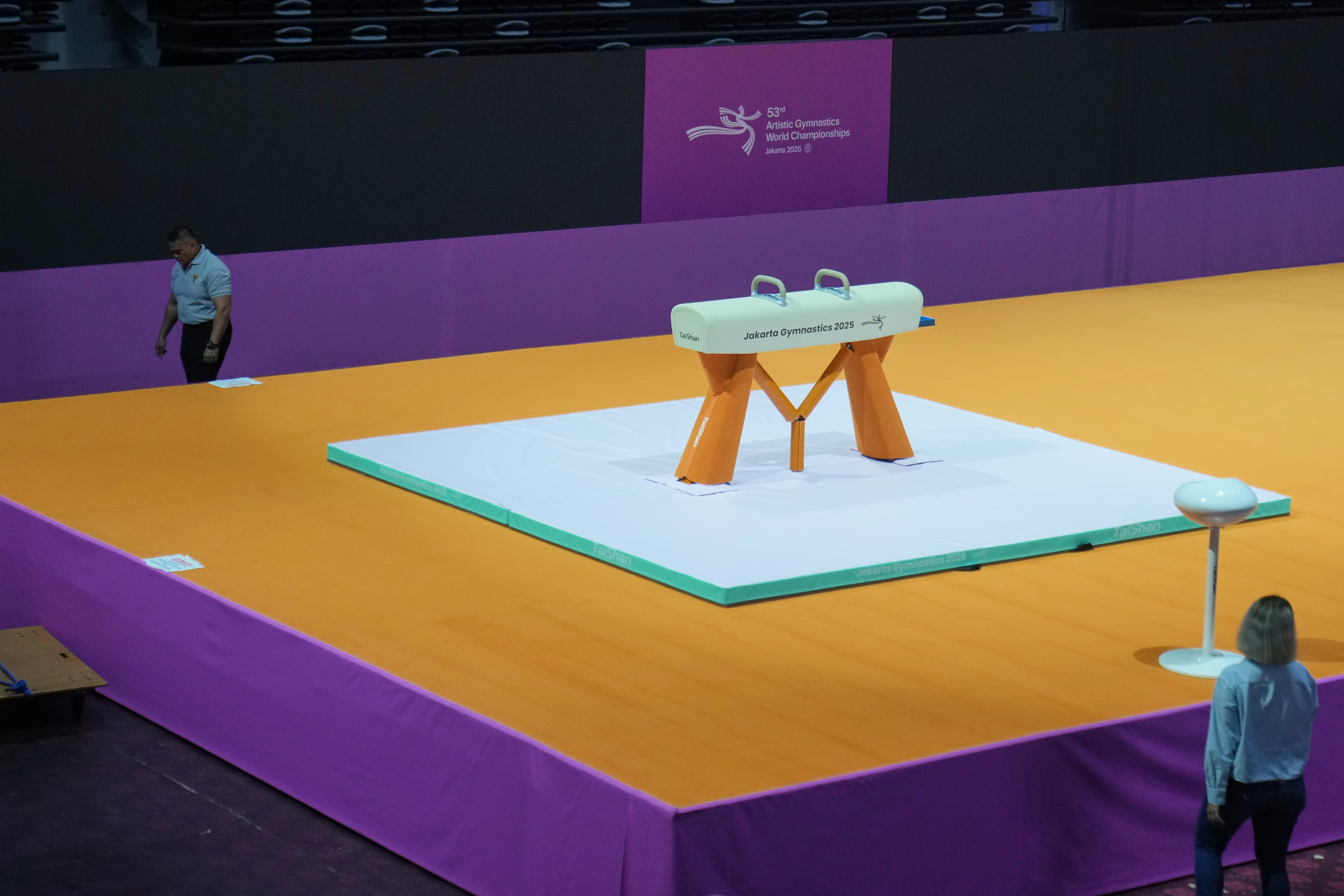 A security guard walks past a pommel horse at the venue prepared for the Artistic Gymnastics World Championships at Indonesia Arena in Jakarta, Indonesia, Friday, Oct. 10, 2025.