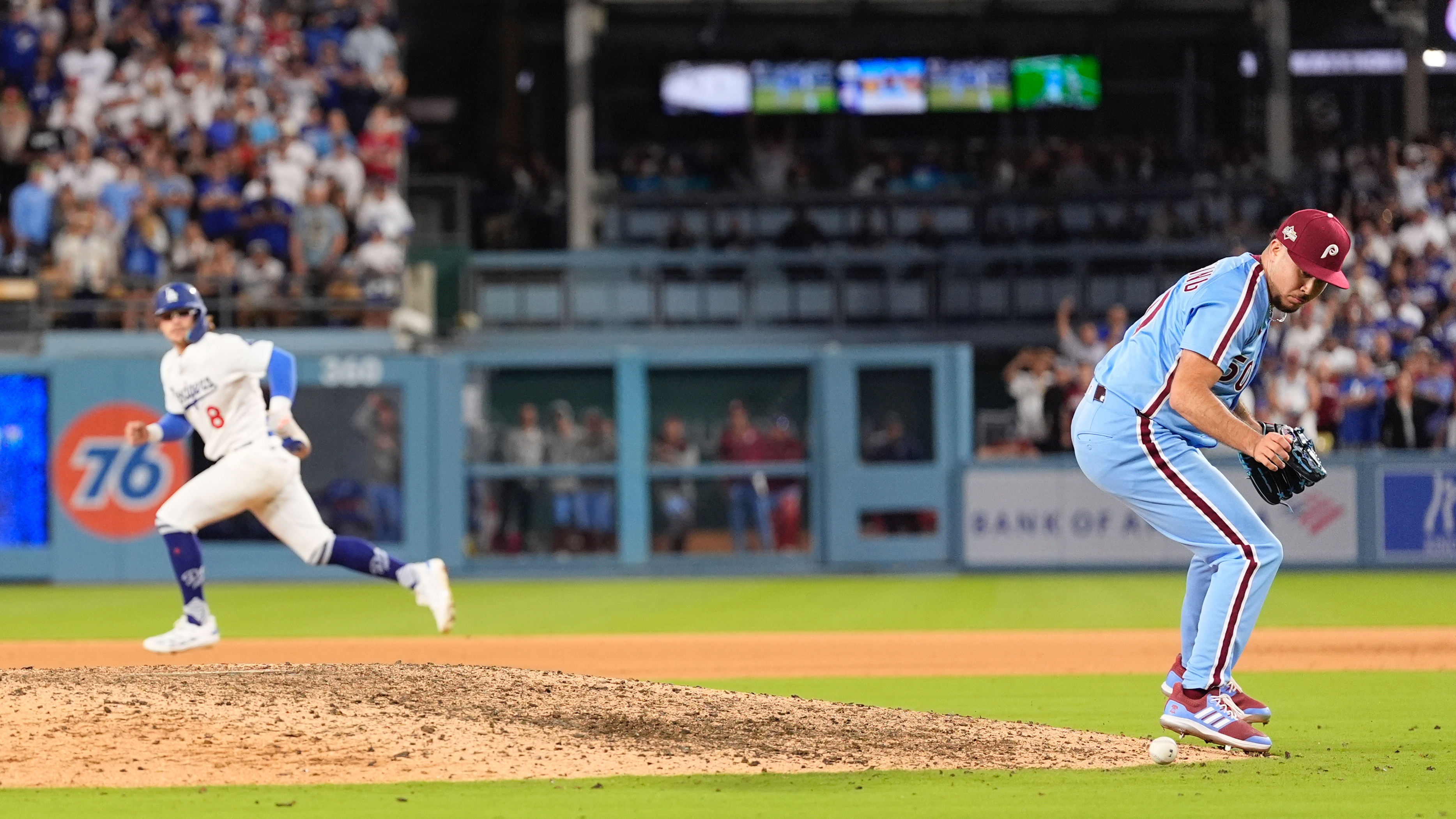 Philadelphia Phillies pitcher Orion Kerkering looks down at a ground ball from Los Angeles Dodgers' Andy Pages before committing a throwing error to home platev and allowing the game-winning run to score during the eleventh inning in Game 4 of baseball's National League Division Series against the Los Angeles Dodgers, Thursday, Oct. 9, 2025, in Los Angeles.