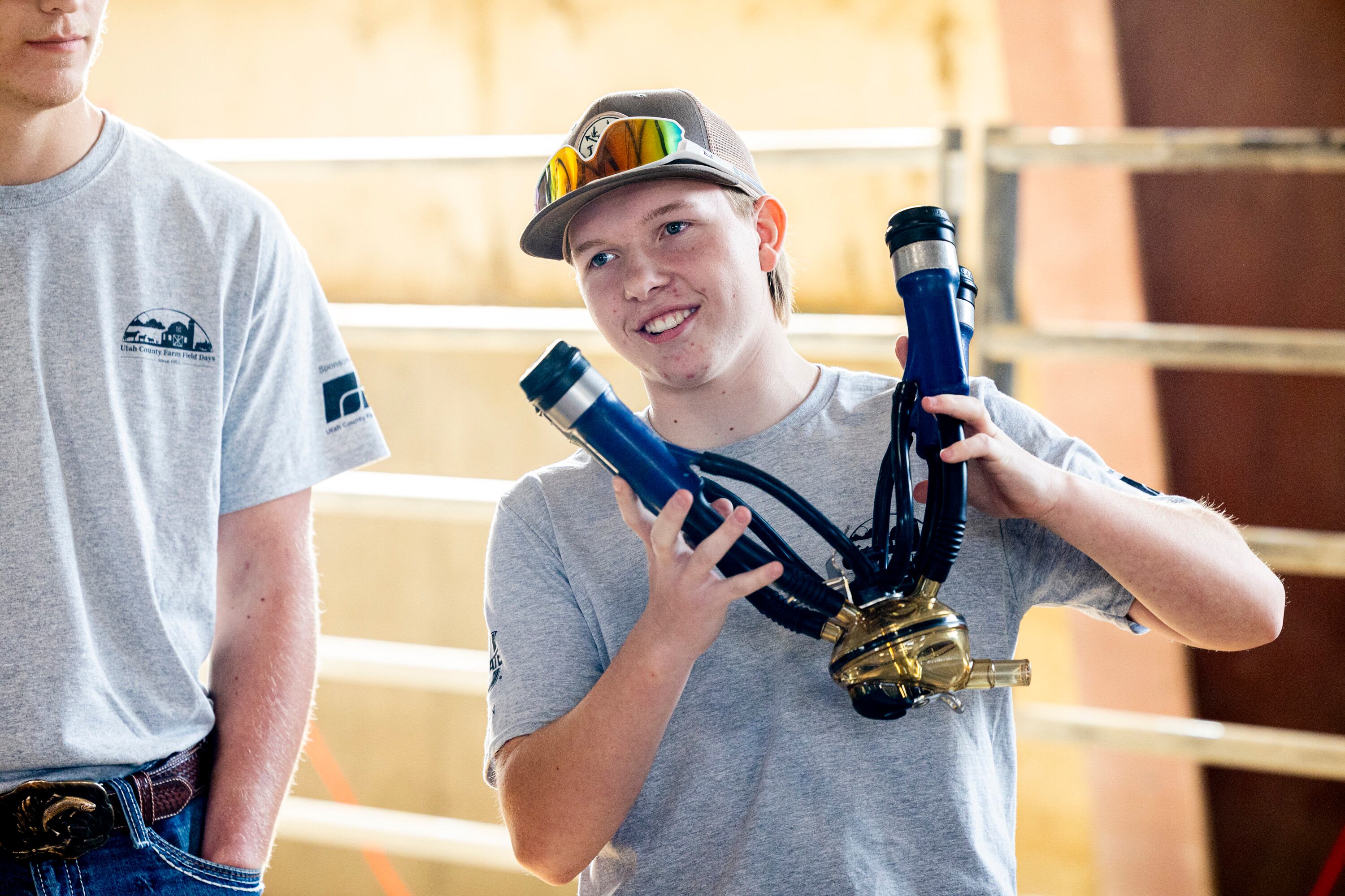 Cody Sorensen, a member of the Future Farmers of America’s Skyridge High School chapter, shows second graders a milk collector used to milk dairy cows during Utah County Farm Field Days held by the Utah Farm Bureau and Utah State University Extension at the North Utah County Equestrian Park in Highland on Thursday.