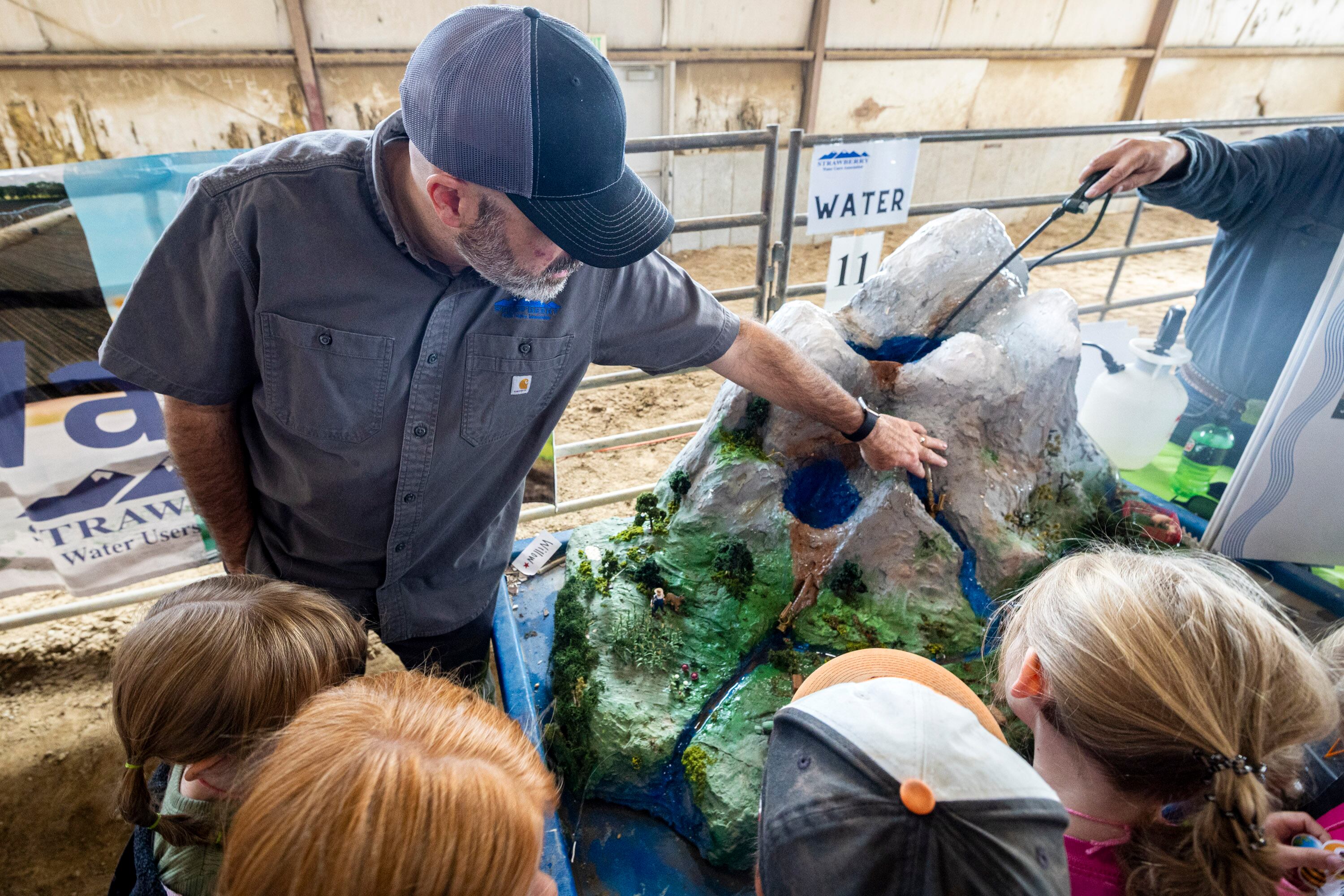 Chris Larsen, with the Strawberry Water Users Association, talks about water runoff and other water-related topics with second graders during Utah County Farm Field Days held by the Utah Farm Bureau and Utah State University Extension at the North Utah County Equestrian Park in Highland on Thursday.