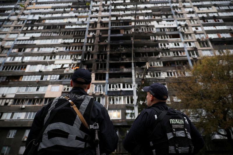 Police look at an apartment building that was damaged during a Russian drone and missile strike in Kyiv, Ukraine, Friday. Ukrainian government officials are calling for support after Russia's ramped-up attacks on the energy sector.