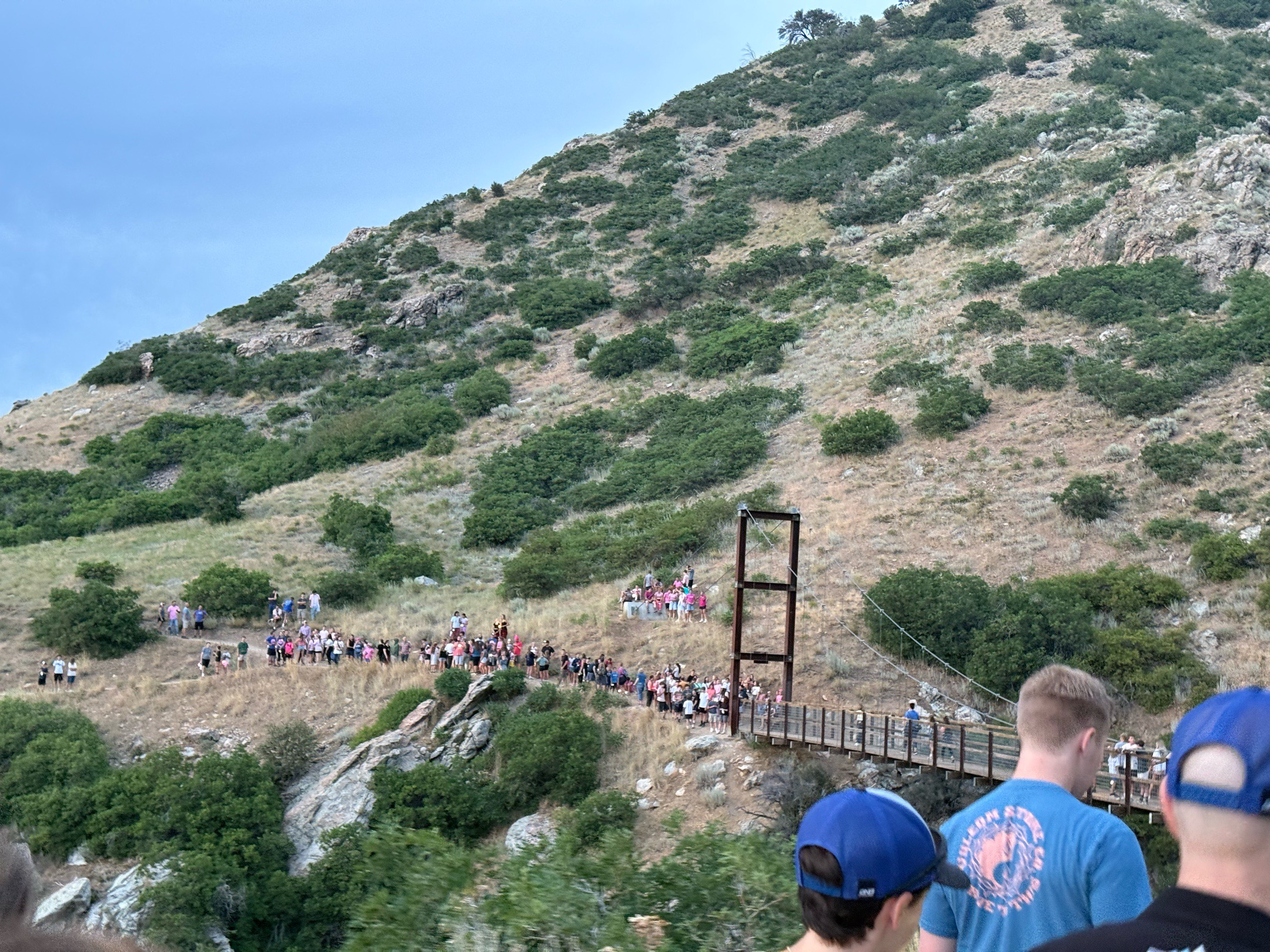 Members of the Draper Park Mountain Bike Team on a memorial hike through the suspension bridge for a vigil in honor of Bailey Mallard, who died in June 2025.
