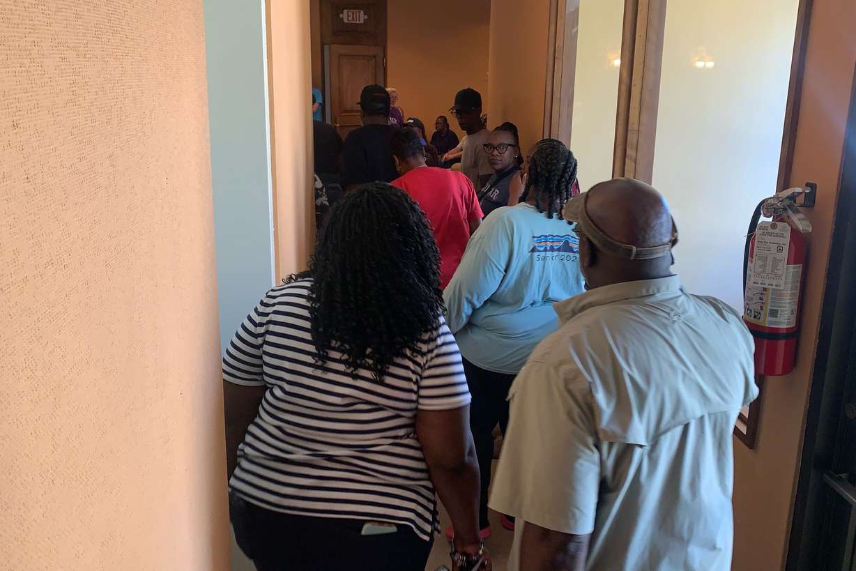 Families of the shooting victims head into a meeting with authorities at Leland City Hall on Saturday. Eight people were killed in separate shootings after high school homecoming celebrations in the area.
