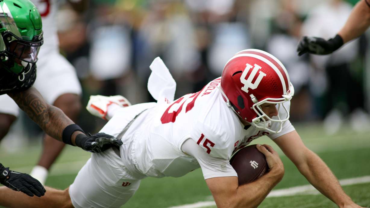 Indiana quarterback Fernando Mendoza (15) slides with the ball during the first half of an NCAA college football game against Oregon, Saturday, Oct. 11, 2025, in Eugene, Ore.