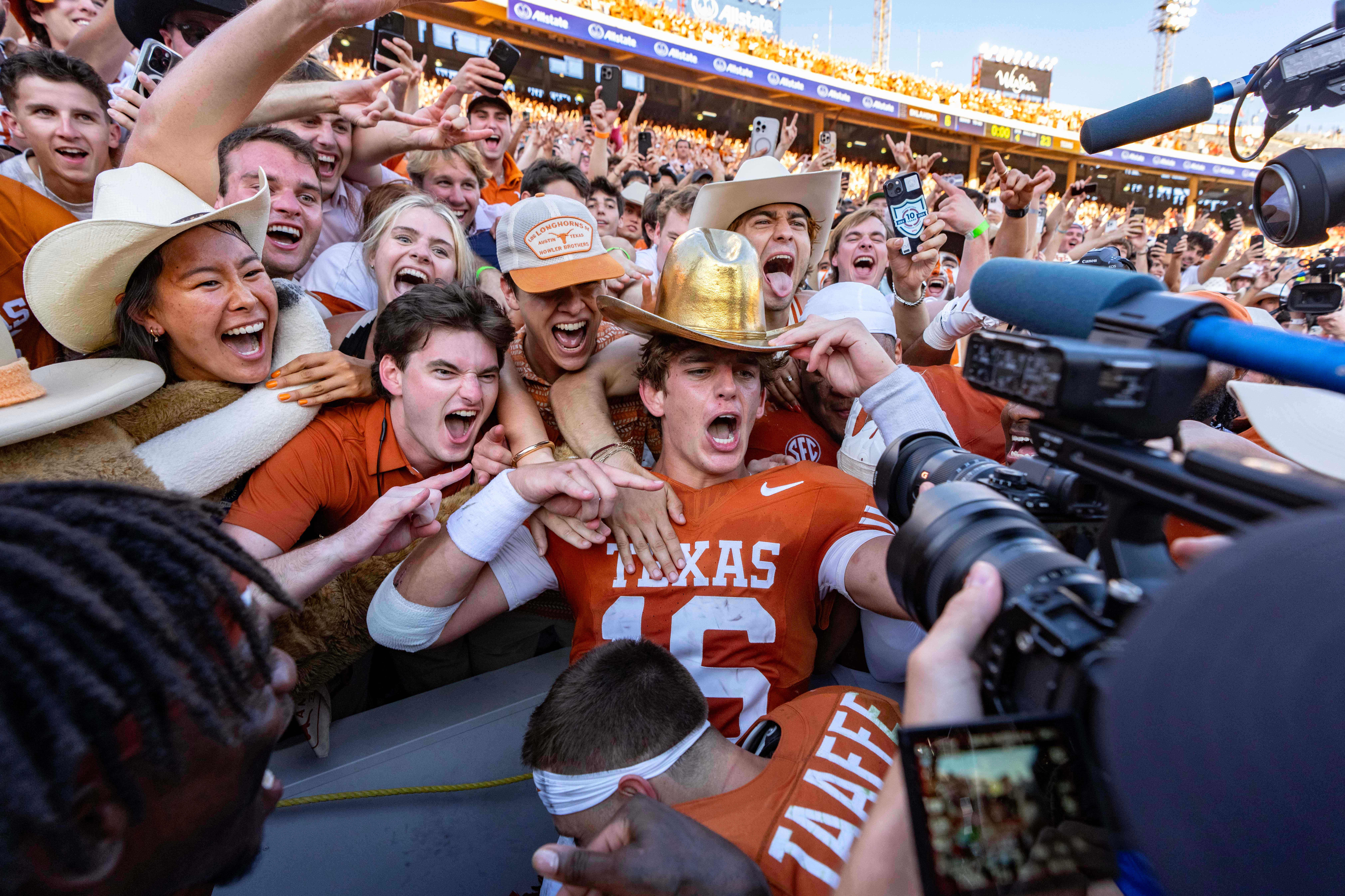 Texas quarterback Arch Manning, center, celebrates with fans after defeating Oklahoma in an NCAA college football game Saturday, Oct. 11, 2025, in Dallas. 