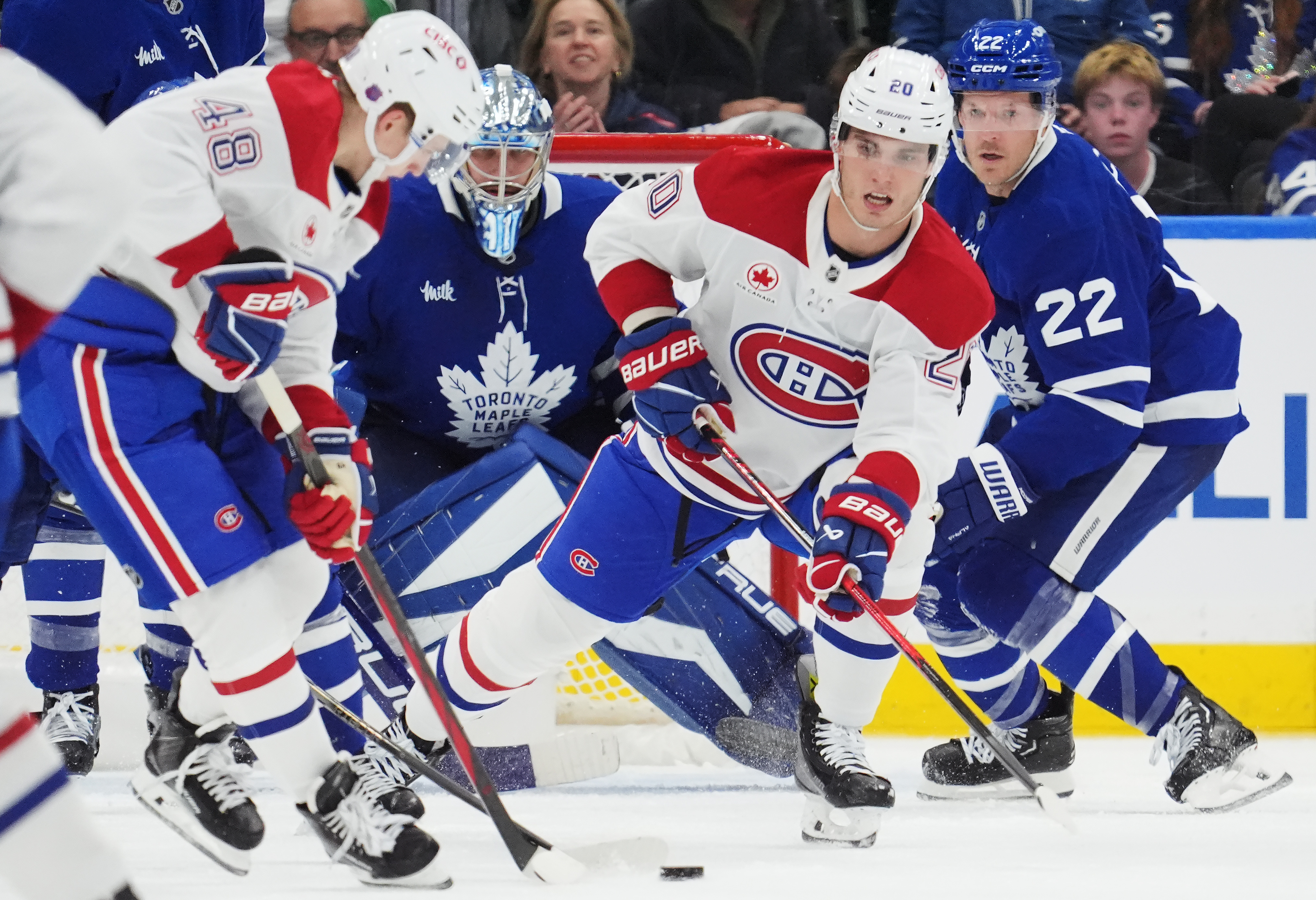 Montreal Canadiens' Lane Hutson (48) and Juraj Slafkovsky (20) work for the puck as Toronto Maple Leafs goaltender Anthony Stolarz (41) and Jake McCabe (22) look on during second period NHL hockey action in Toronto on Wednesday, Oct. 8, 2025. 