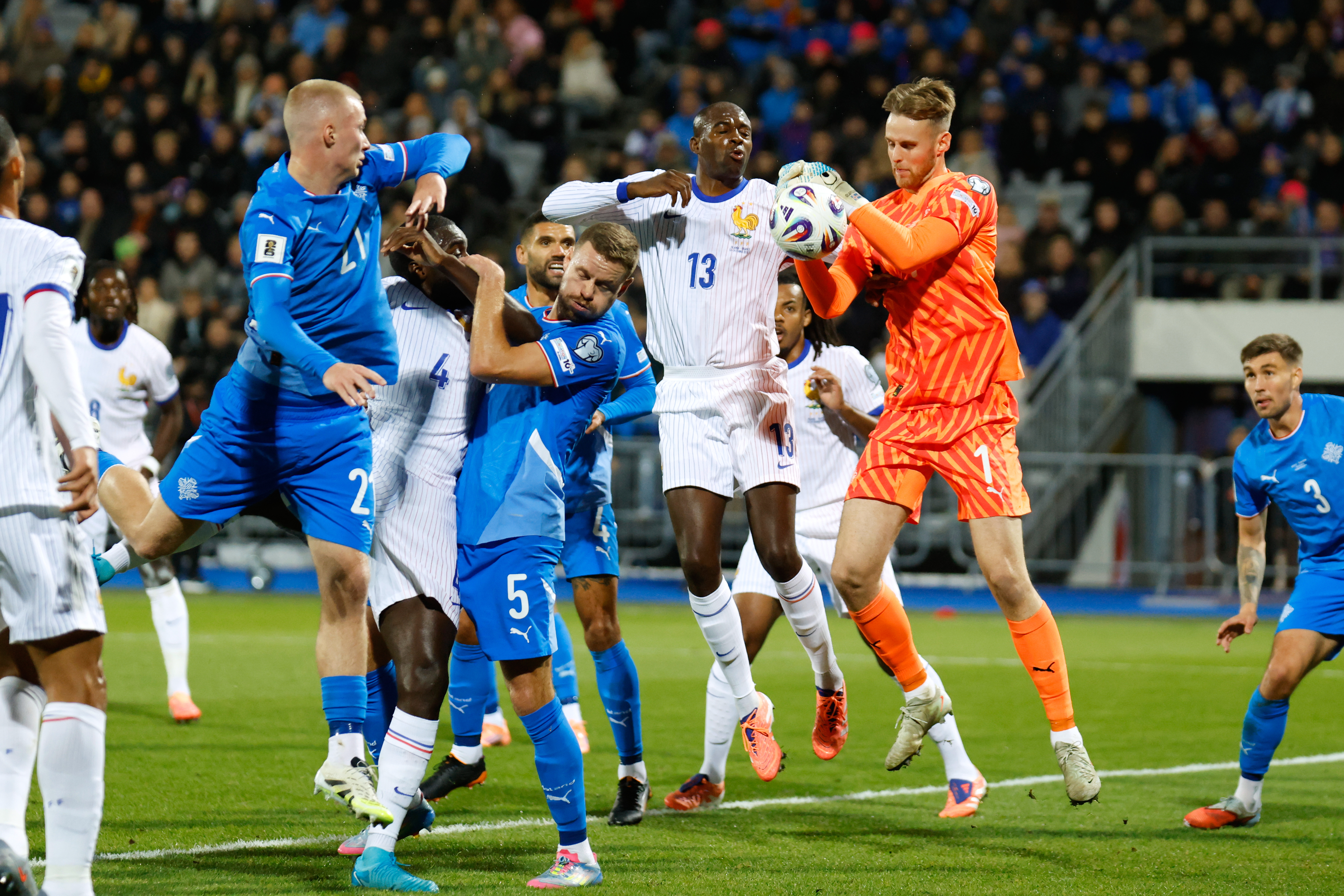 Iceland goalkeeper Elias Rafn Olafsson gets to the ball ahead of France's Jean-Philippe Mateta, center, during a World Cup 2026 group D qualifying soccer match between Iceland and France in Reykjavik, Monday, Oct. 13, 2025. 
