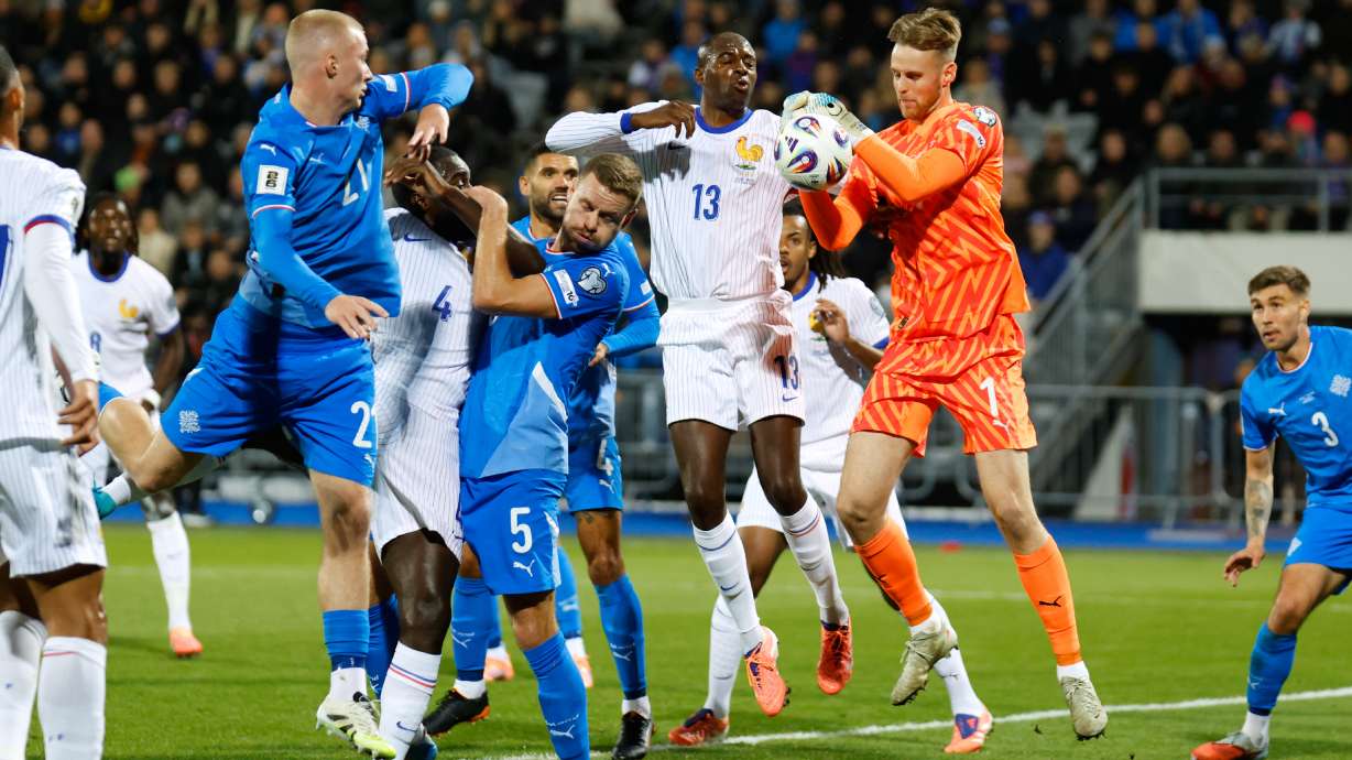 Iceland goalkeeper Elias Rafn Olafsson gets to the ball ahead of France's Jean-Philippe Mateta, center, during a World Cup 2026 group D qualifying soccer match between Iceland and France in Reykjavik, Monday, Oct. 13, 2025.