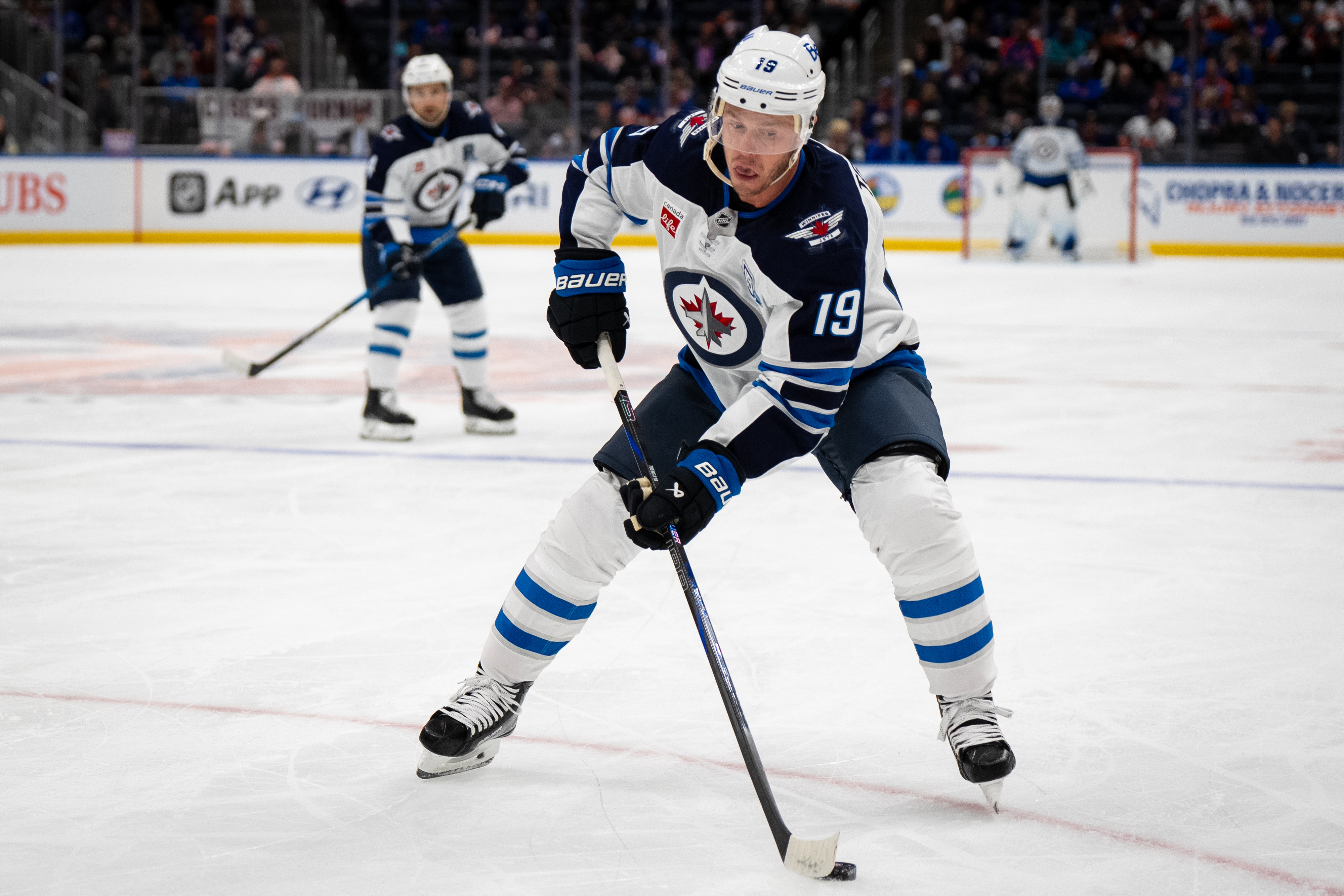 Winnipeg Jets center Jonathan Toews (19) controls the puck during the second period of an NHL hockey game against the New York Islanders, Monday, Oct. 13, 2025, in Elmont, N.Y.