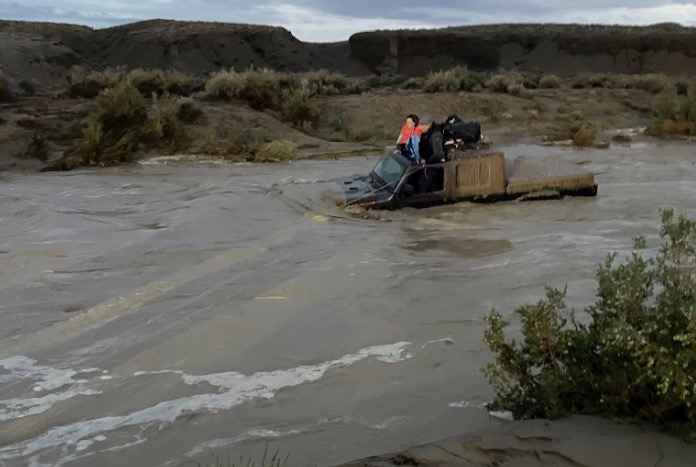 Two people are rescued after flood waters overtake their vehicle in Grand County on Friday.