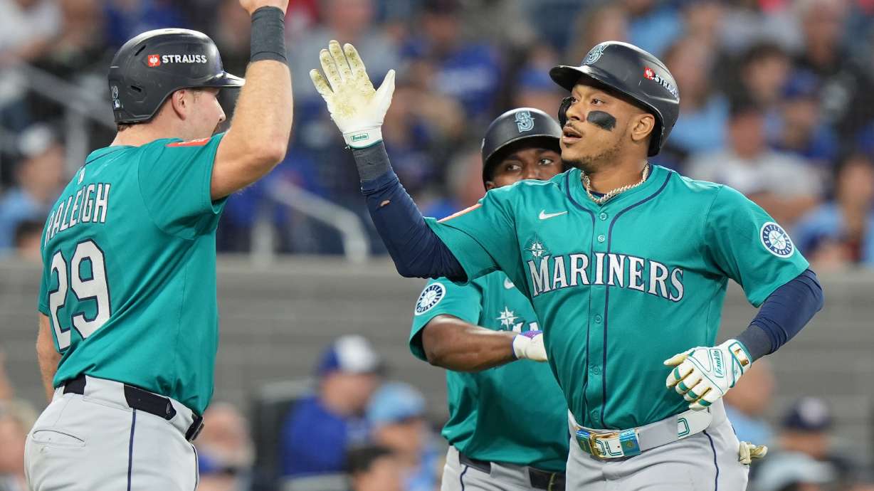 Seattle Mariners' Jorge Polanco, right, celebrates after his a three-run home run with Cal Raleigh (29) during the fifth inning of Game 2 of baseball's American League Division Series against the Toronto Blue Jays in Toronto, Monday, Oct. 13, 2025.