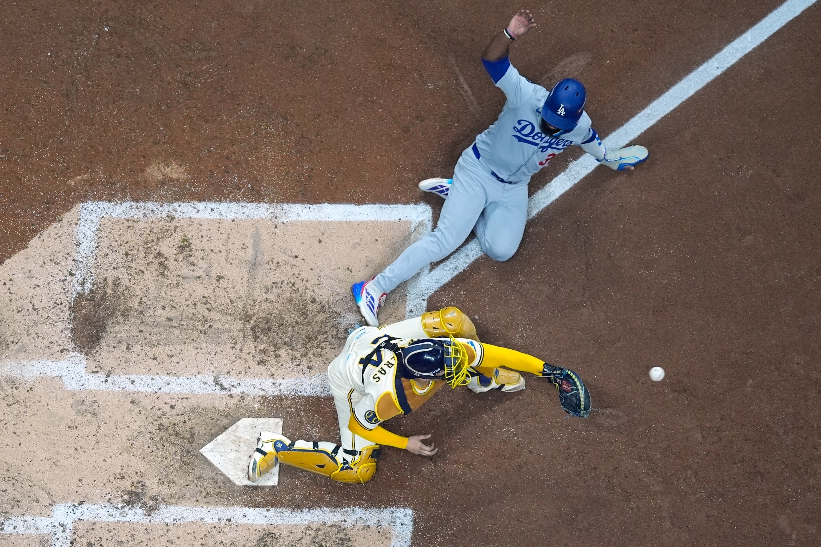 Los Angeles Dodgers' Teoscar Hernández is out at home as Milwaukee Brewers catcher William Contreras takes the throw during the fourth inning of Game 1 of baseball's National League Championship Series Monday, Oct. 13, 2025, in Milwaukee.