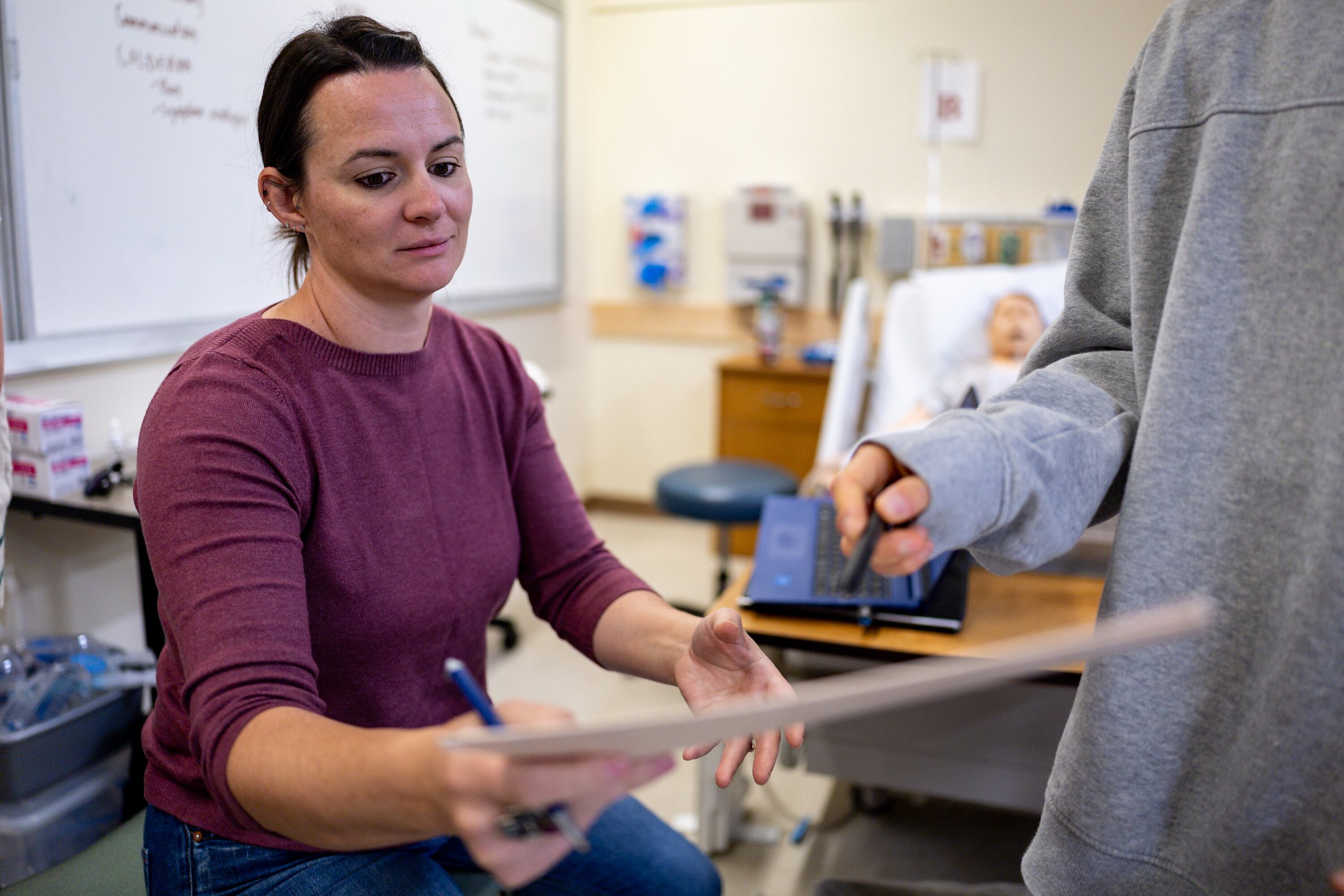 Co-instructor Michelle Carnell, left, signs papers for students after teaching the Foundations 2 lab class at Westminster's School of Nursing and Health Sciences in Salt Lake City on Sept. 24.