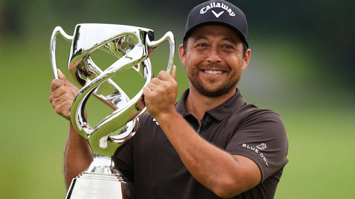 Xander Schauffele, of the U.S., poses for a photo with his trophy after he won the Baycurrent Classic golf tournament at the Yokohama Country Club in Yokohama, near Tokyo, Sunday, Oct. 12, 2025.