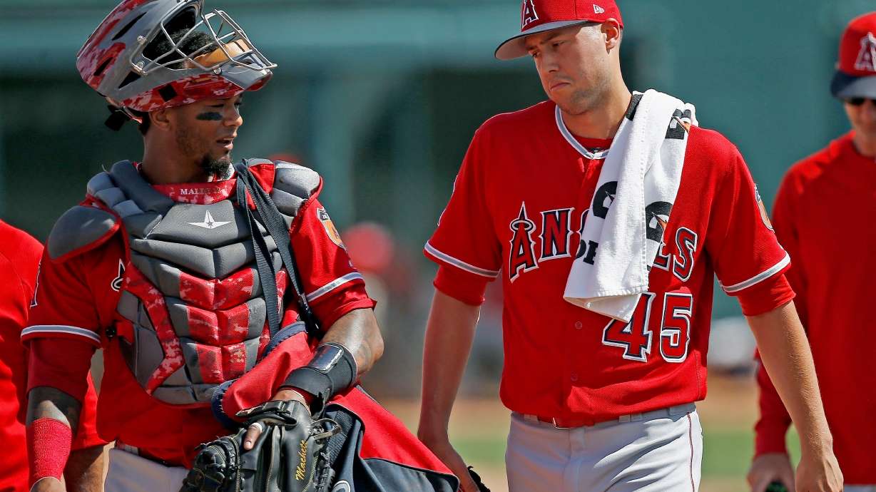 FILE - Los Angeles Angels starting pitcher Tyler Skaggs (45) talks with catcher Martin Maldonado, left, after warming up in the bullpen prior to a spring training baseball game against the Chicago White Sox, March 4, 2017, in Glendale, Ariz.