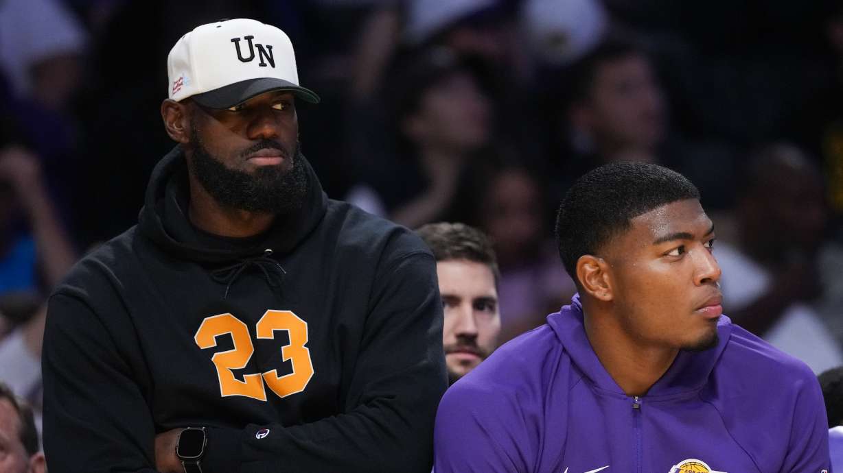 Los Angeles Lakers' Lebron James, left, and Rui Hachimura watch action from the bench during the first half of a preseason NBA basketball game against the Golden State Warriors Sunday, Oct. 12, 2025, in Los Angeles.