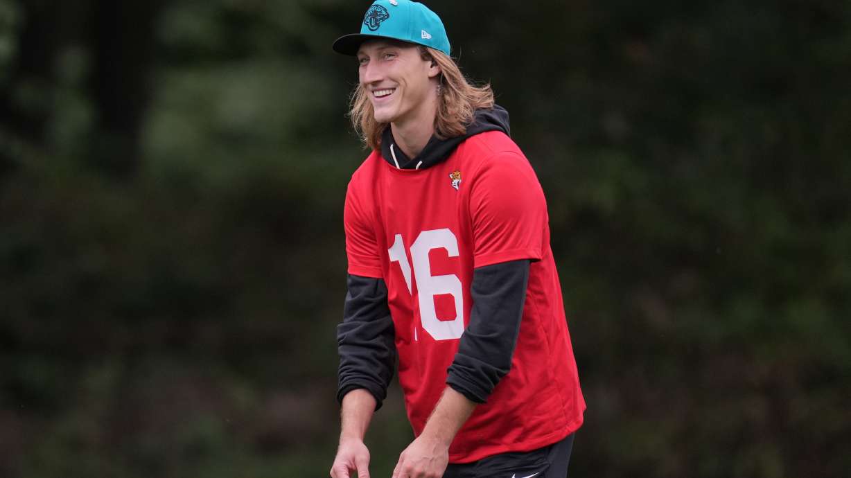 Jacksonville Jaguars quarterback Trevor Lawrence (16) smiles during an NFL football practice at The Grove in Watford, England, Wednesday, Oct. 15, 2025.