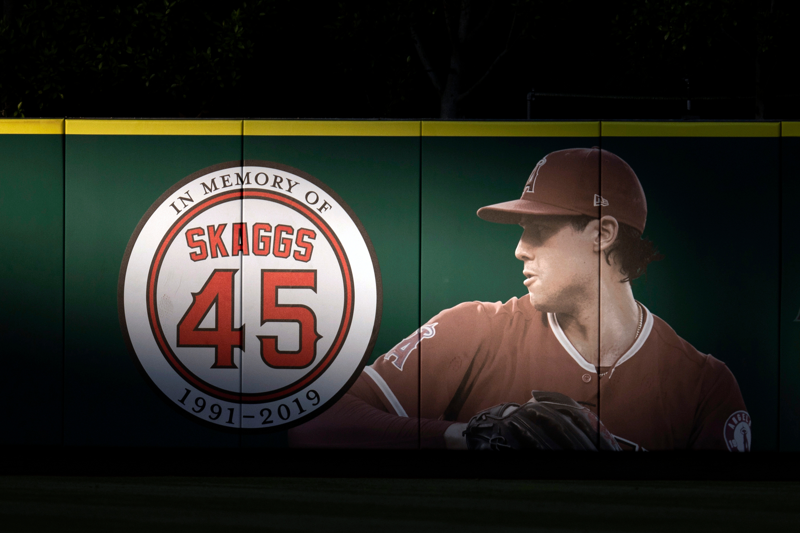 FILE - An image and logo memorializing former Los Angeles Angels pitcher Tyler Skaggs is displayed on the outfield wall in Anaheim, Calif., July 17, 2019. 