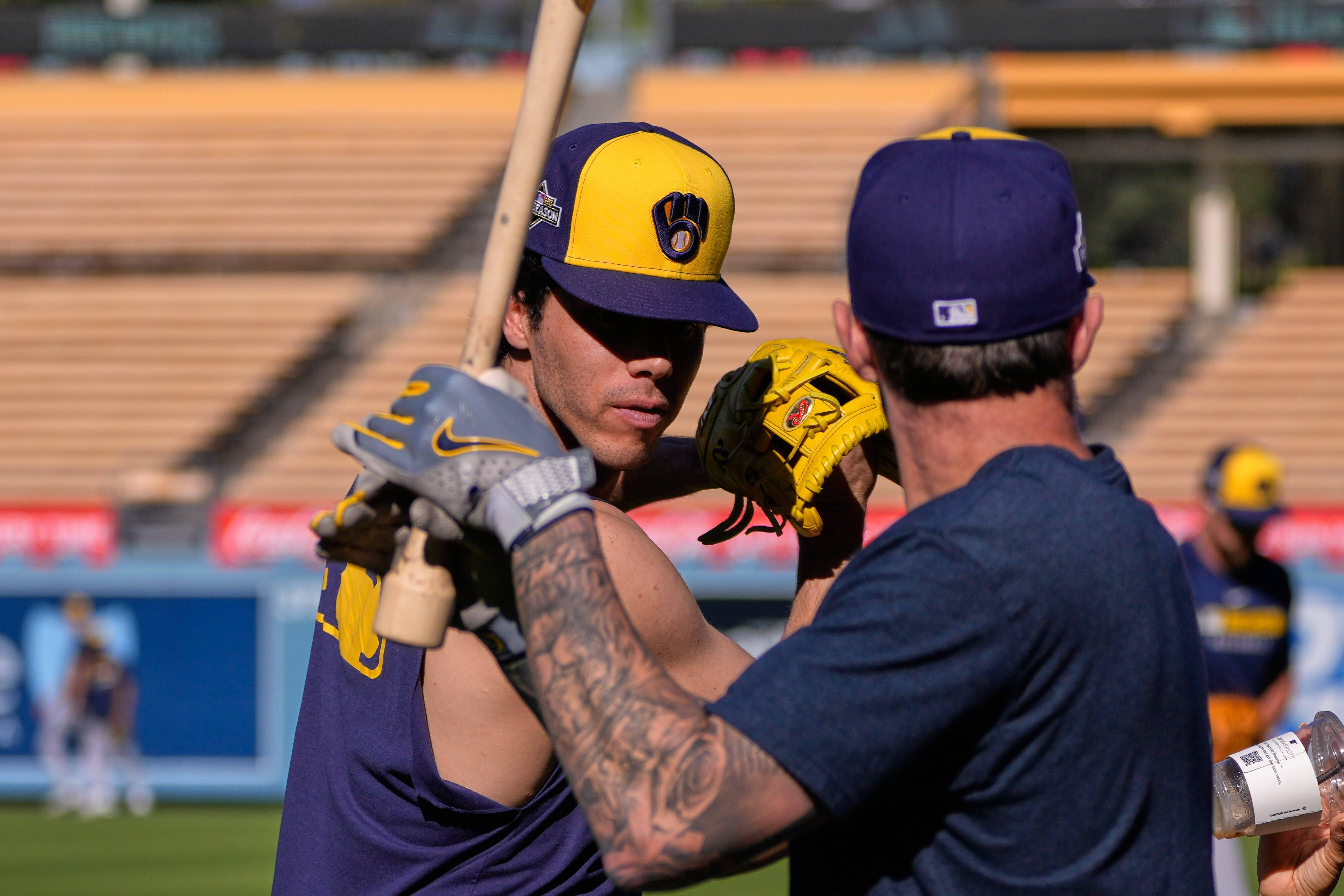 Milwaukee Brewers' Christian Yelich, left, and Brice Turang warm up during practice ahead of Game 3 of baseball's National League Championship Series against the Los Angeles Dodgers, Wednesday, Oct. 15, 2025, in Los Angeles. 