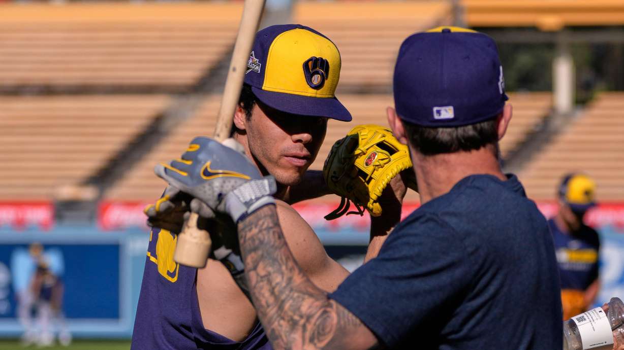 Milwaukee Brewers' Christian Yelich, left, and Brice Turang warm up during practice ahead of Game 3 of baseball's National League Championship Series against the Los Angeles Dodgers, Wednesday, Oct. 15, 2025, in Los Angeles.
