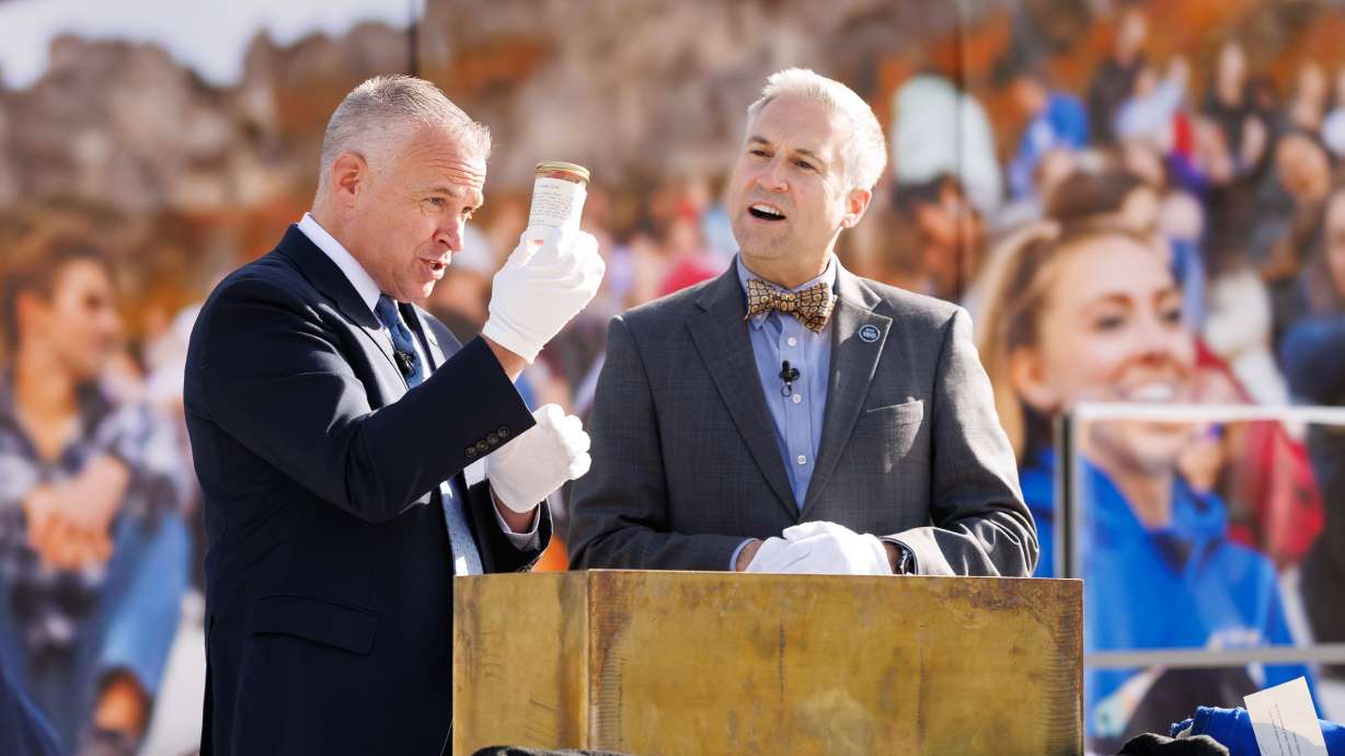 BYU President C. Shane Reese and university librarian Rick Anderson open a time capsule in Provo on Thursday. A game-worn BYU football jersey, a crisp $5 bill and an old gavel belonging to President Dallin H. Oaks were among the discoveries.